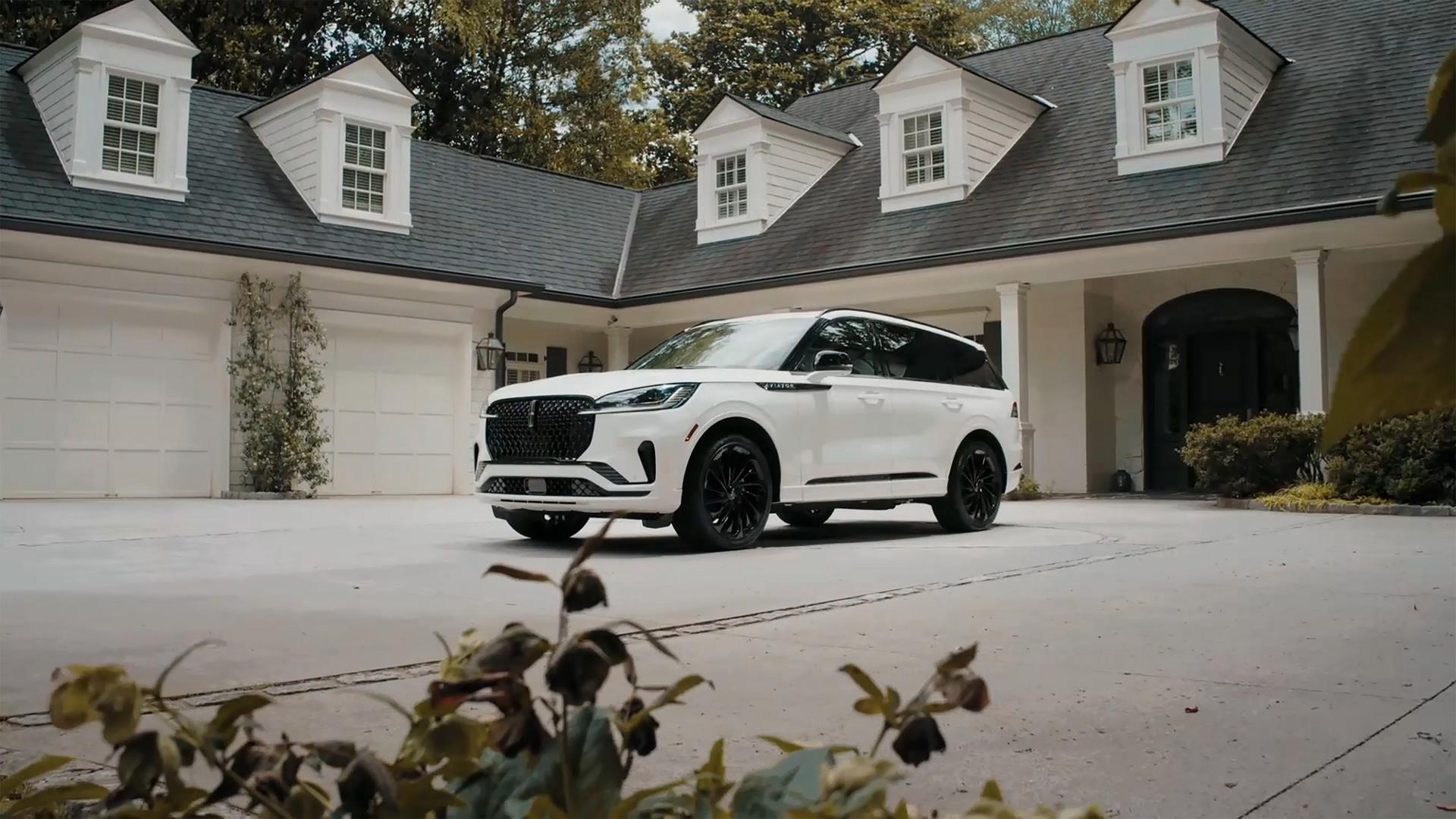 A 2026 Lincoln Aviator is parked in the driveway of a luxury home