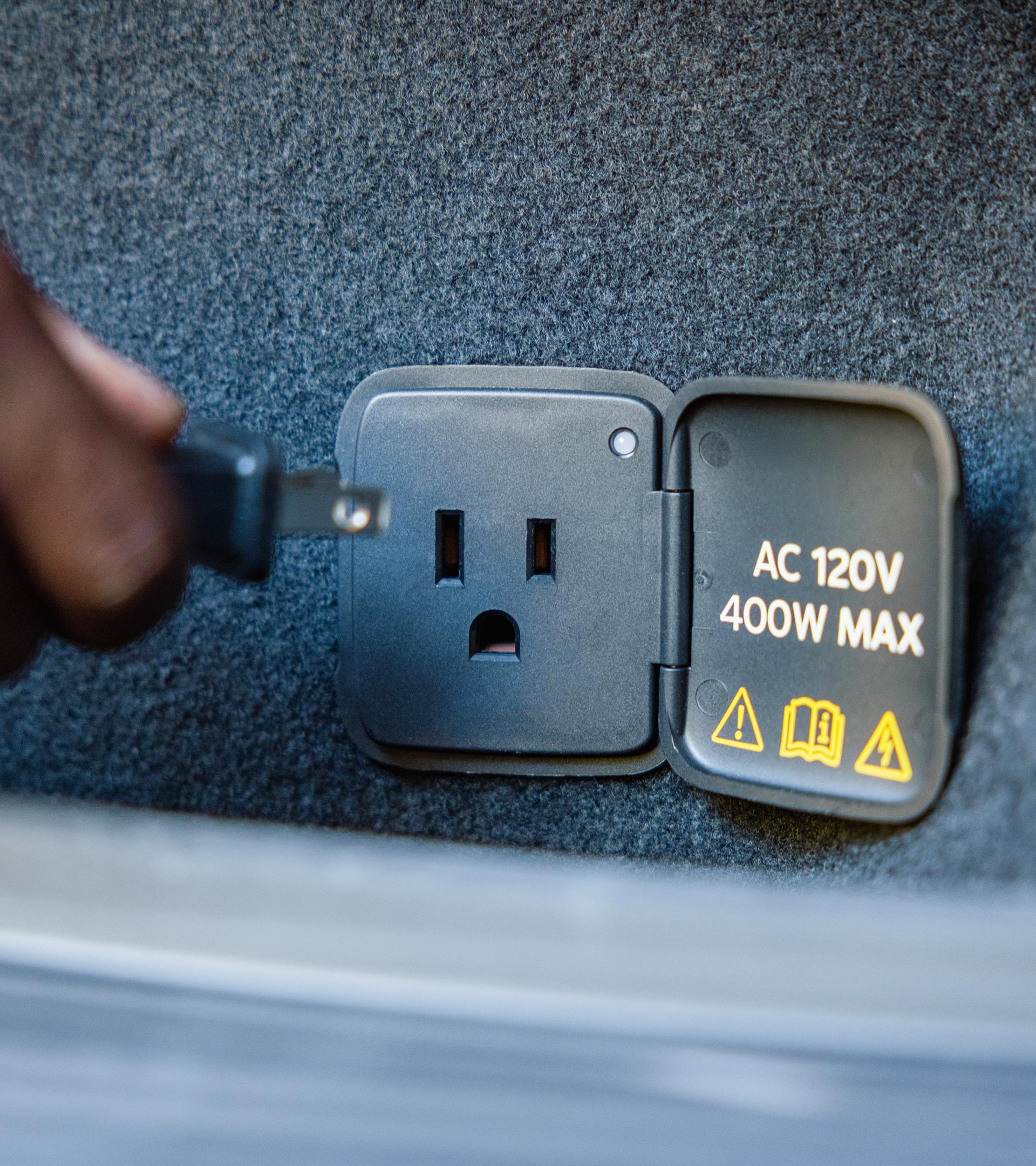 A 110V outlet in the cargo area of a 2027 Ford Mustang Mach-E® SUV with optional Trail package