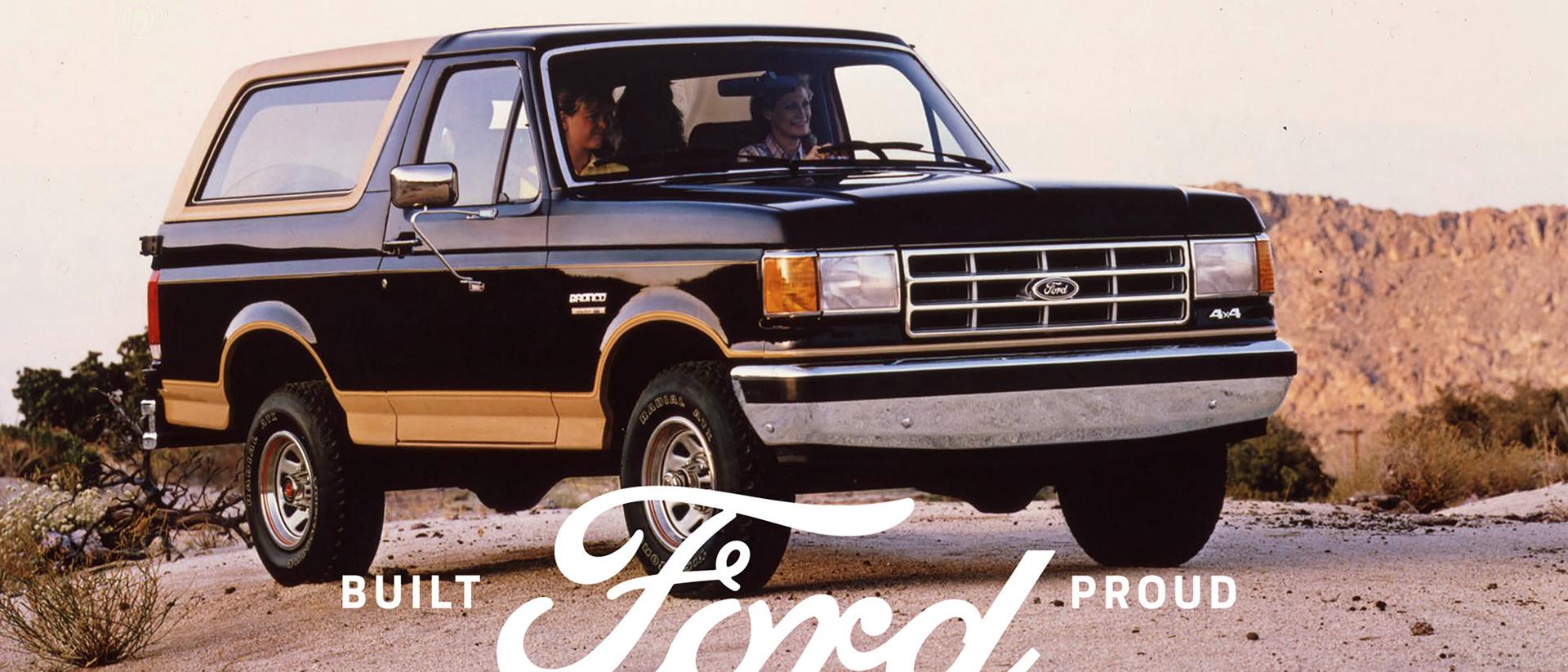A vintage tri-tone Ford Bronco® model parked in front of a desert landscape