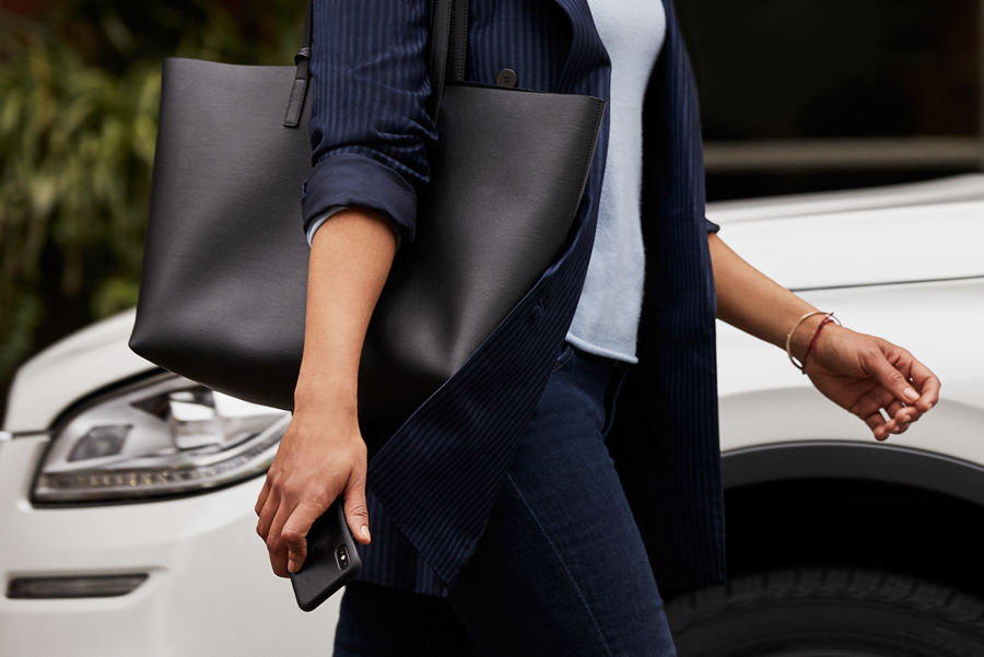 A person is shown approaching a Lincoln vehicle with their smartphone in their hand