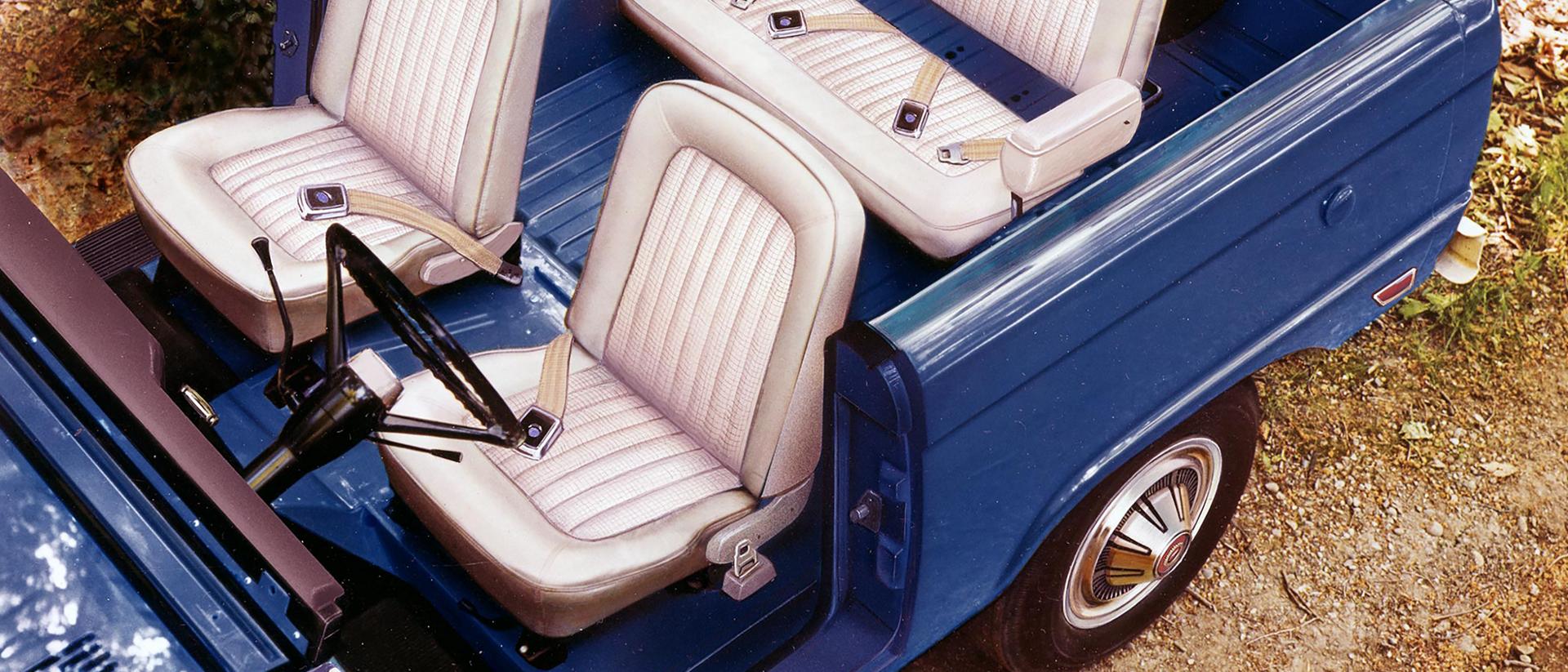 A 1969 Ford Bronco® pictured parked with the doors off and roof removed to showcase the interior