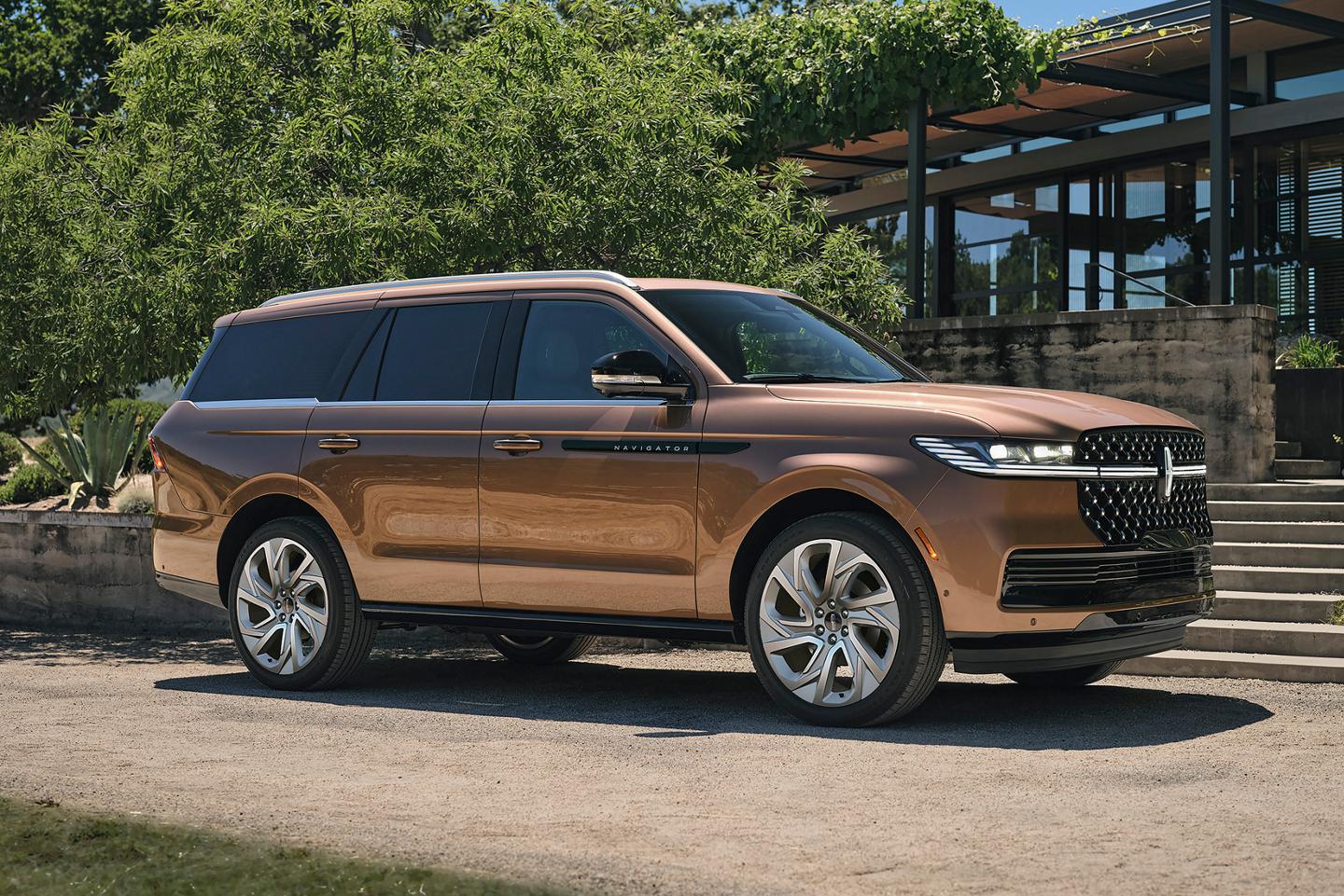 Una SUV Lincoln Black Label Navigator® 2025 estacionada en la entrada de una casa moderna