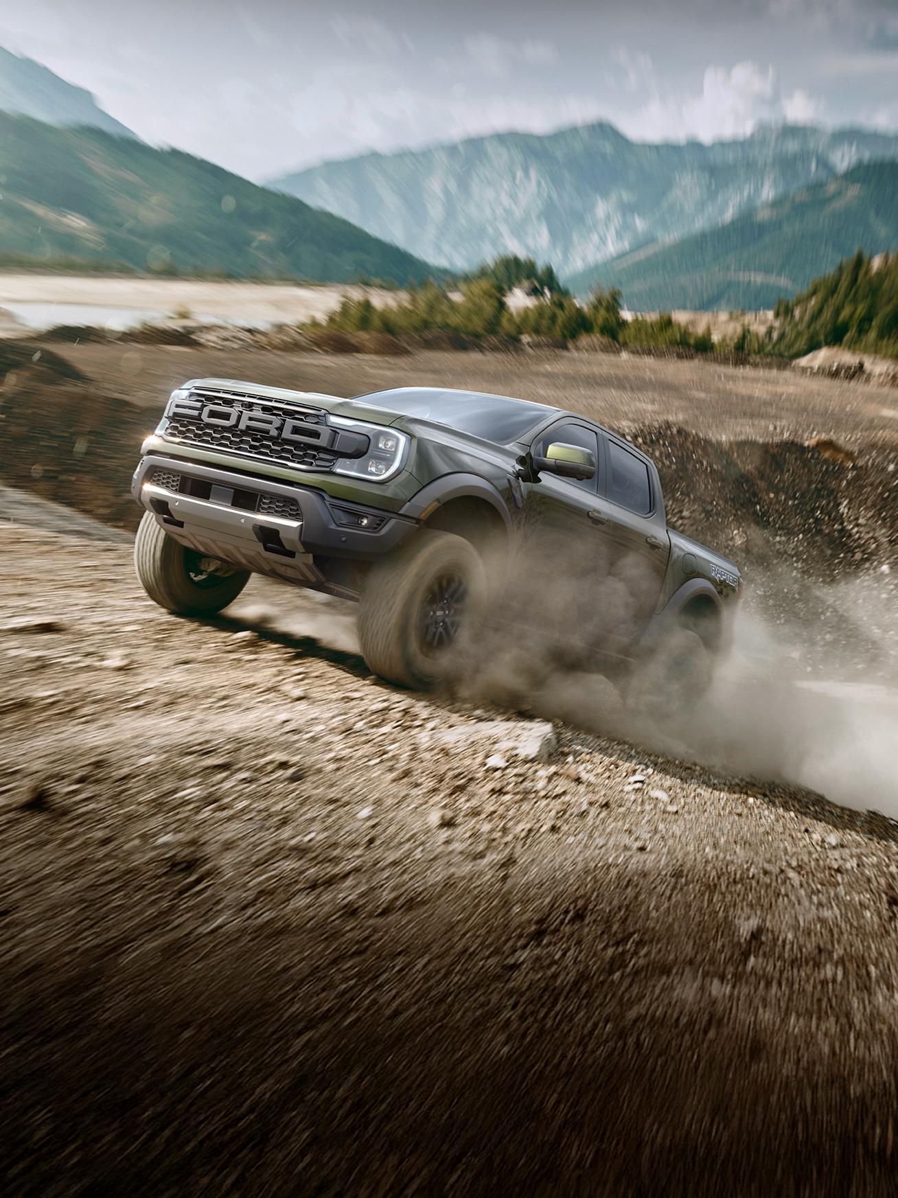 A gray 2026 Ford Ranger® Raptor® moving around a corner, kicking up a large plume of dust from its tires