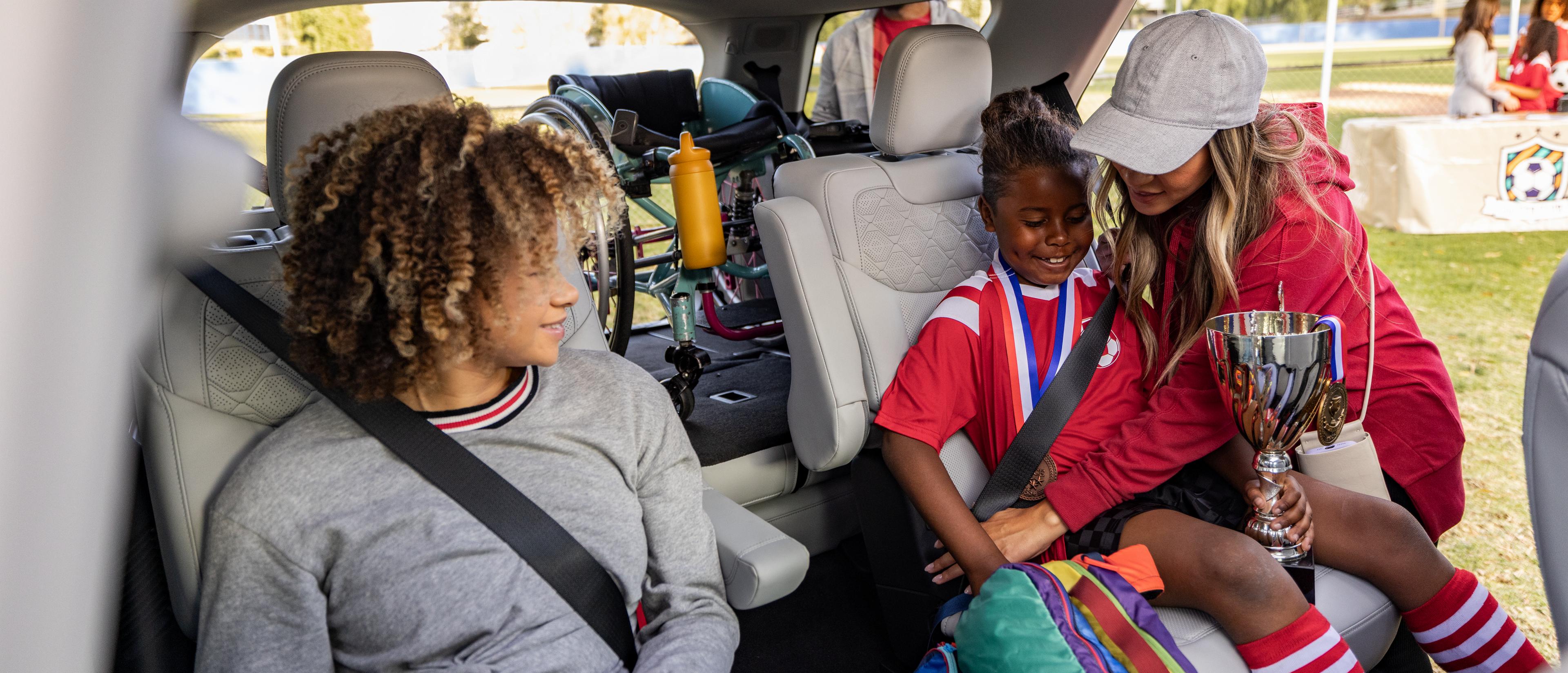 A woman helping children into the rear seats of a 2026 Ford Explorer® SUV