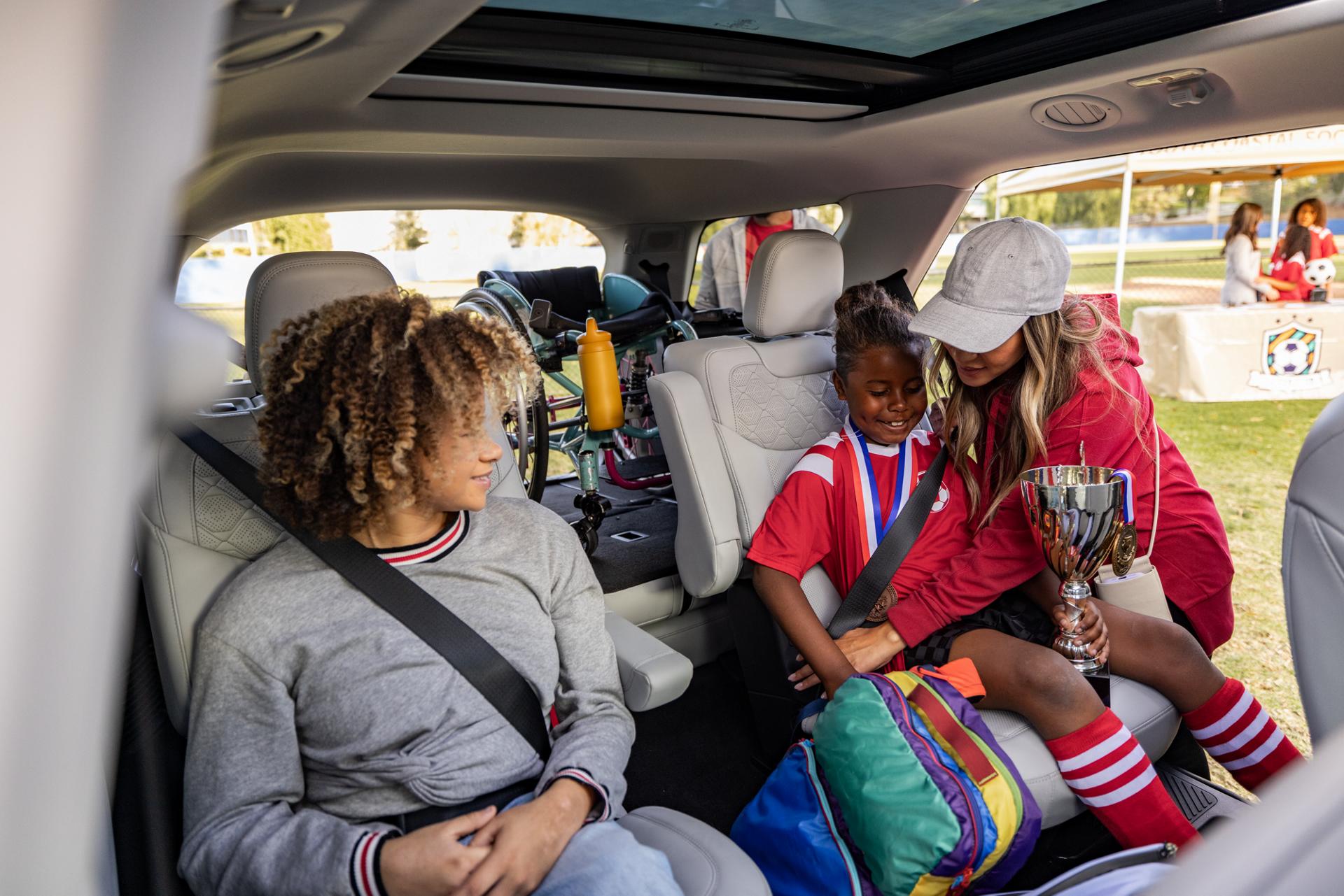 A woman helping children into the rear seats of a 2026 Ford Explorer® SUV