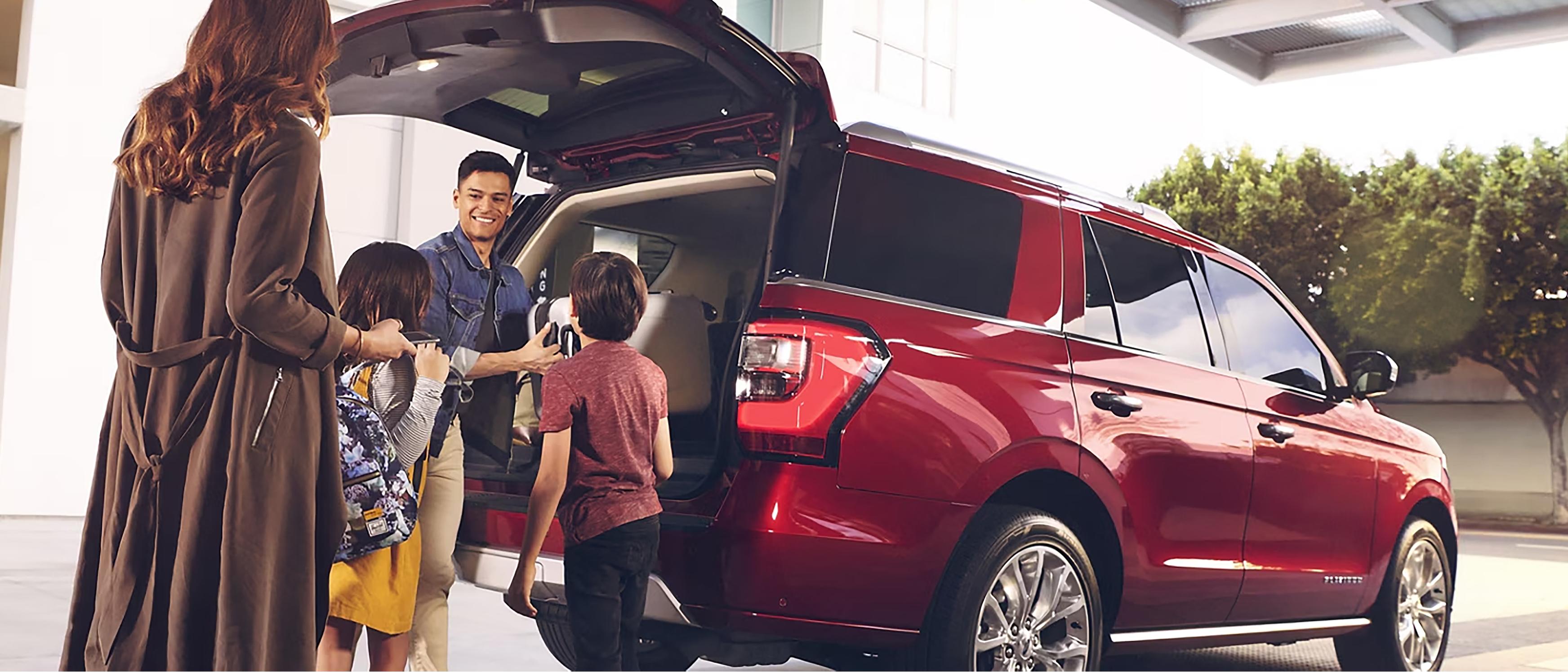 A family unload luggage from their Ford Expedition® SUV in front of their hotel