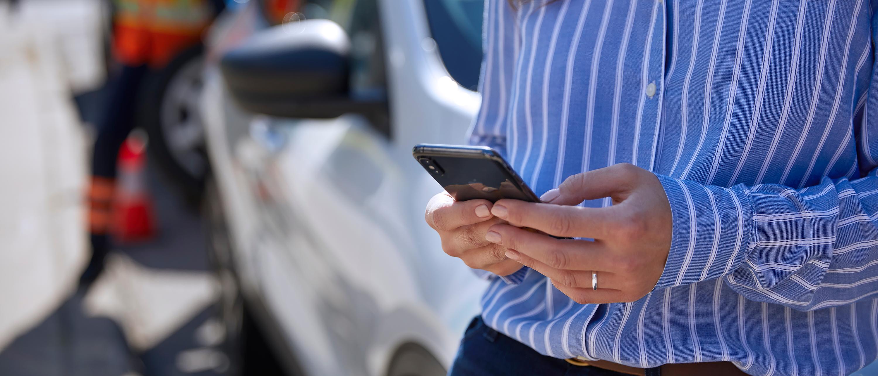 A person on their phone at the scene of an accident