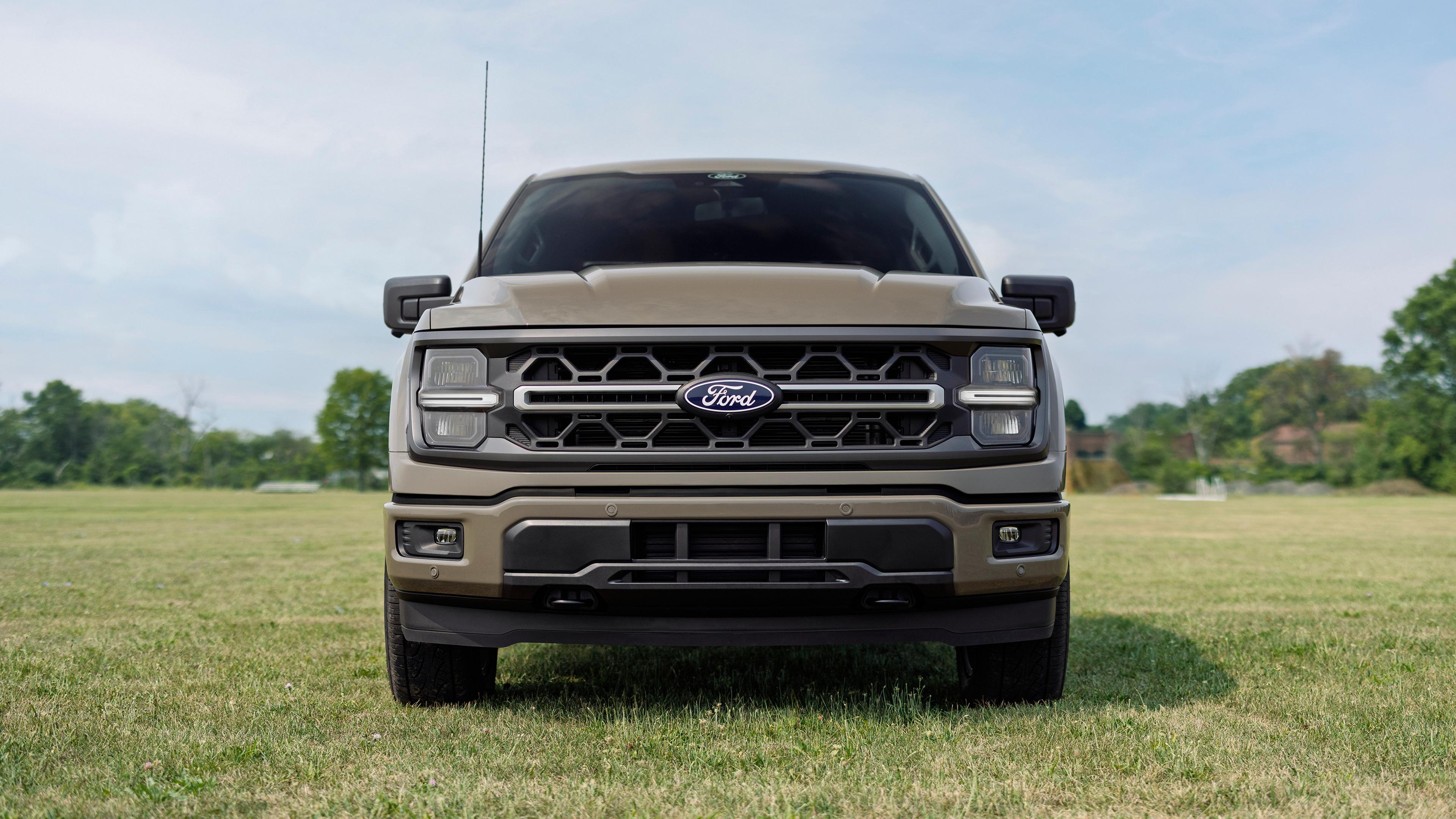 Front view of the grille on a 2027 Ford F-150® XLT model with the Carhartt® Package parked in a field