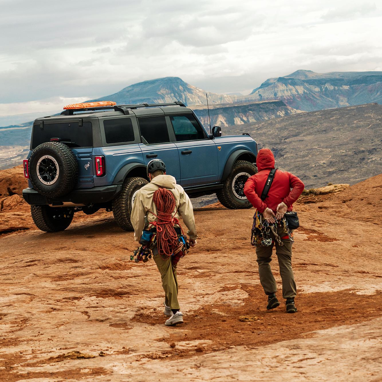 Two rock climbers return to their 2025 Ford Bronco® SUV after a day of climbing