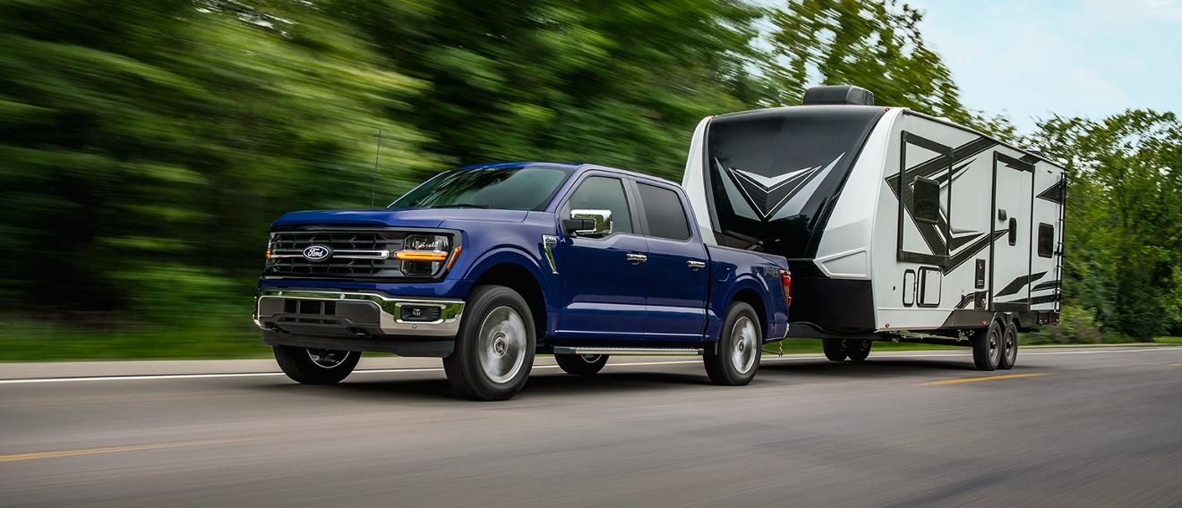 Una camioneta Ford F-150® remolcando un tráiler en una carretera