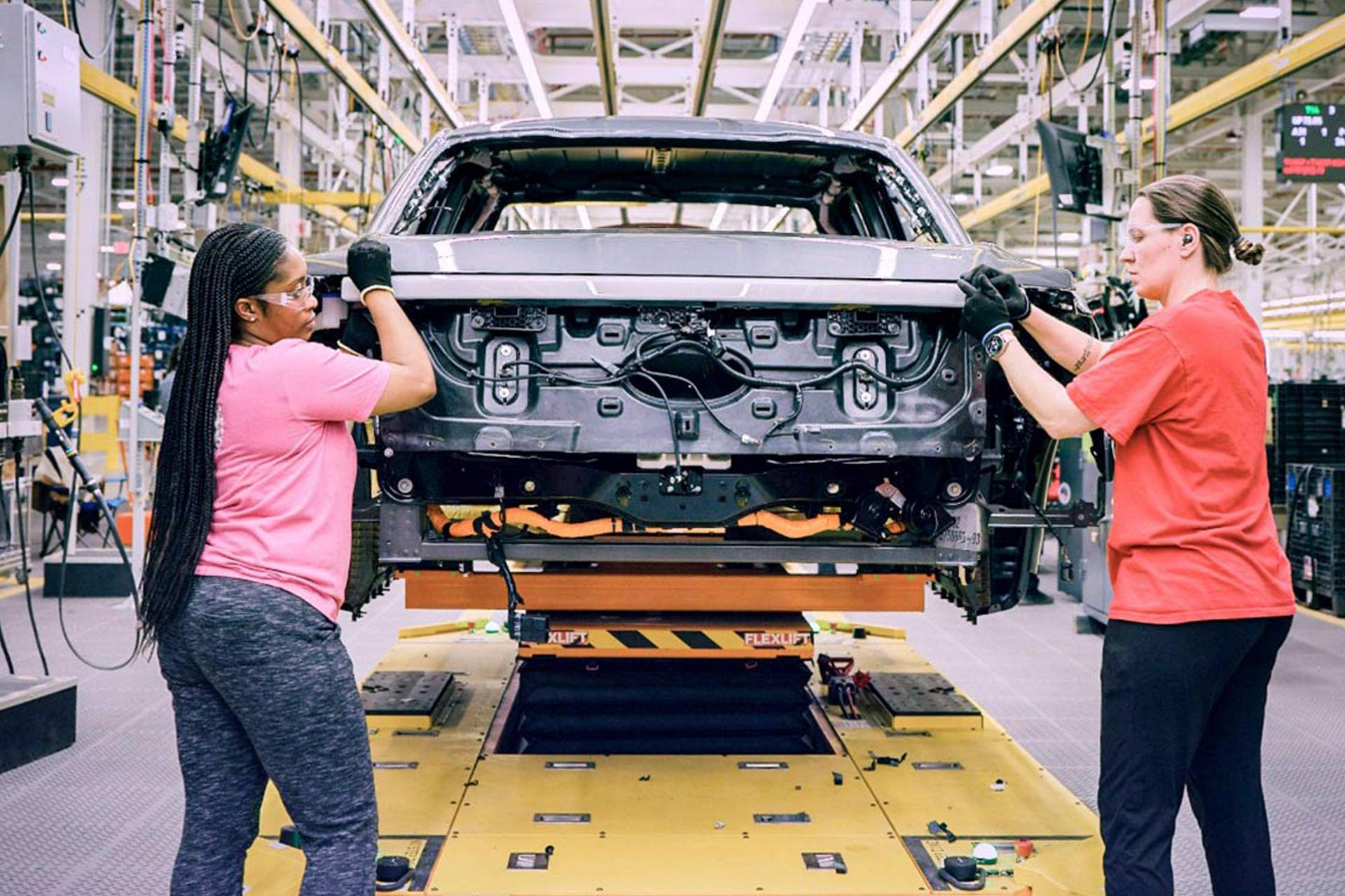 Two assembly line workers at work on a Ford pickup