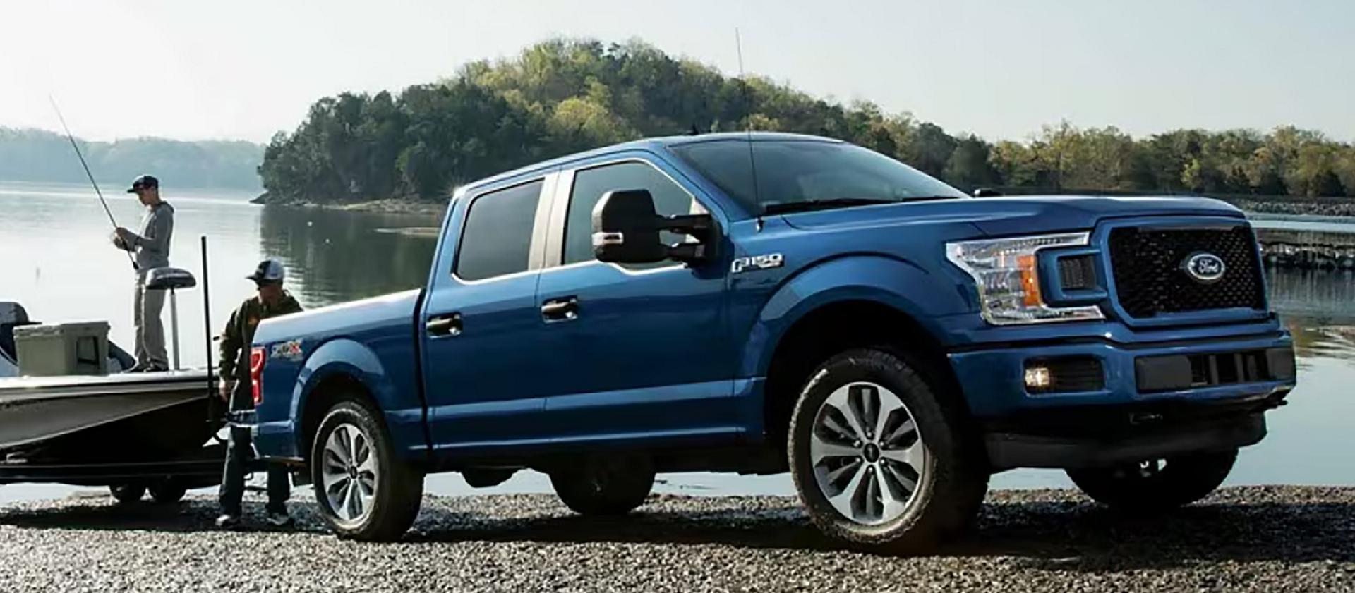 An F-150® truck owner on a boat launch puts their boat into the water