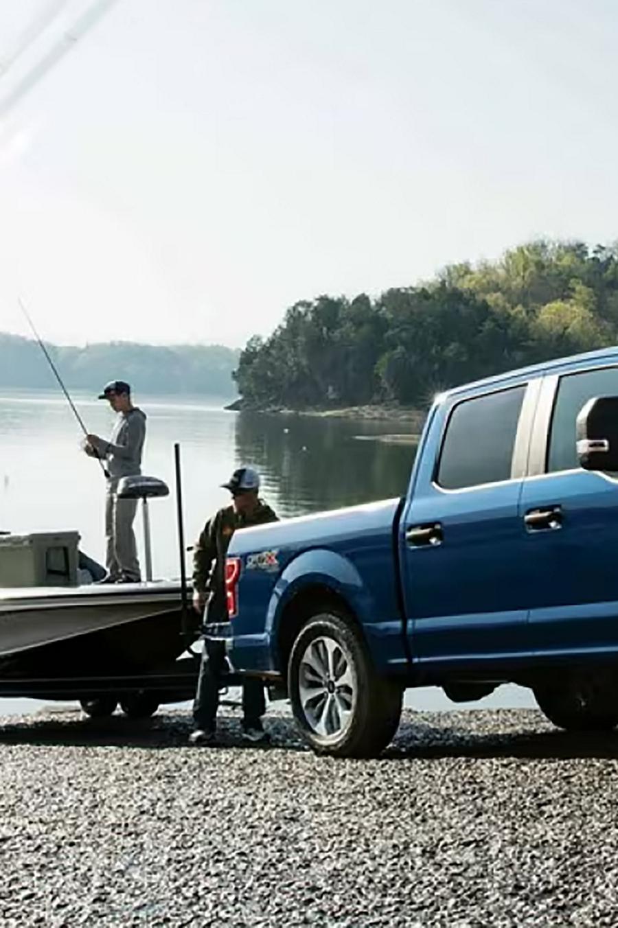 An F-150® truck owner on a boat launch puts their boat into the water