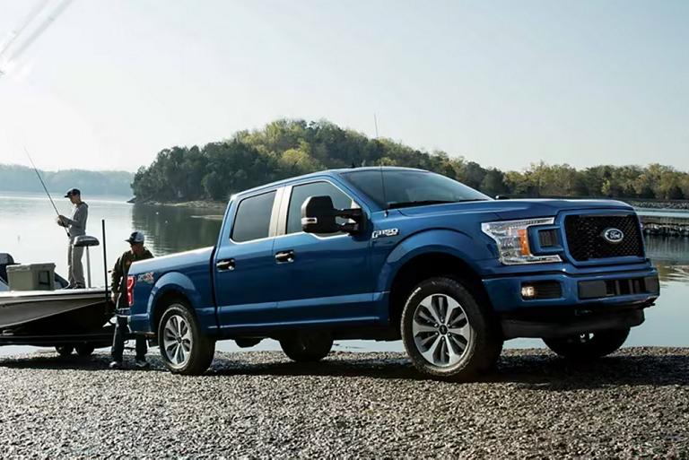 An F-150® truck owner on a boat launch puts their boat into the water