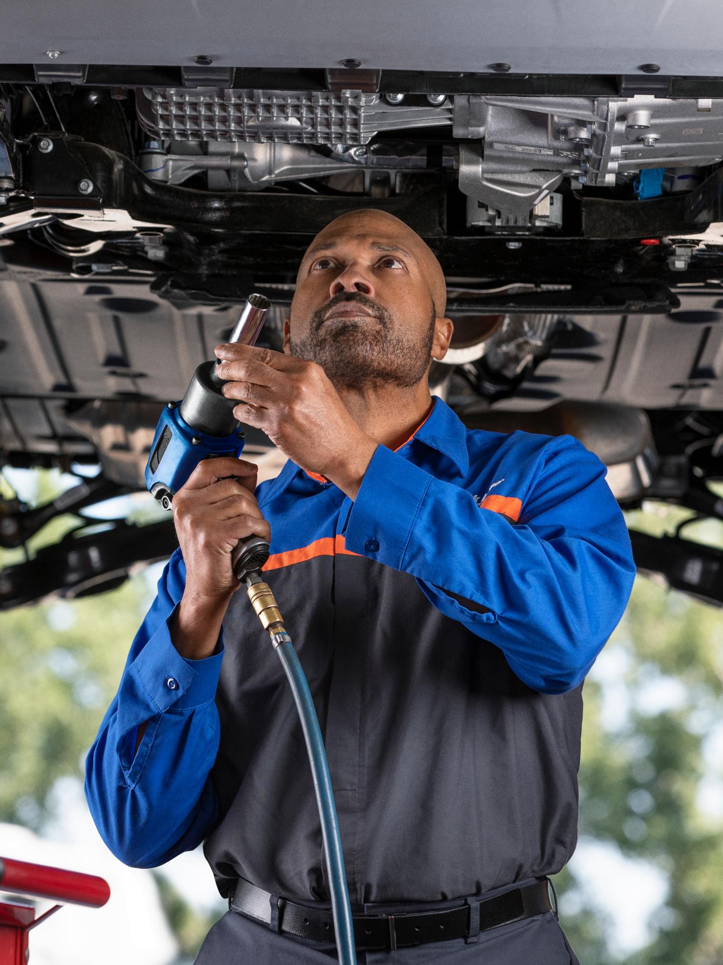 Un garage Service technique Ford avec un homme entretenant un véhicule Ford