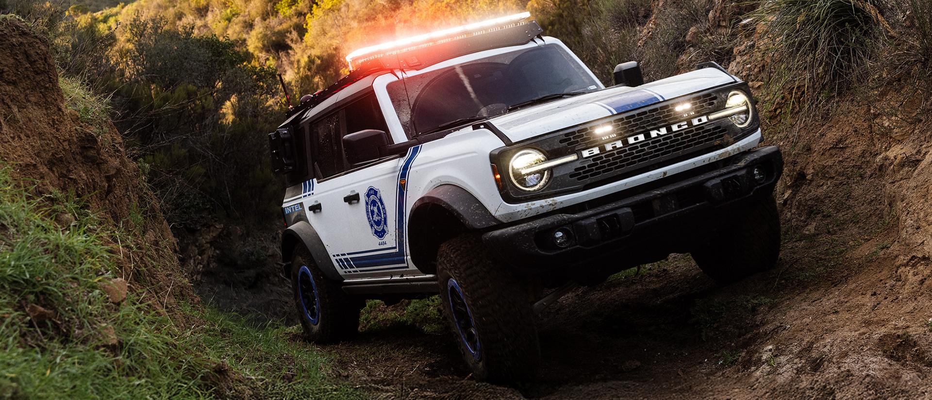 A Ford Bronco Badlands equipped with search and rescue gear driving on an incline