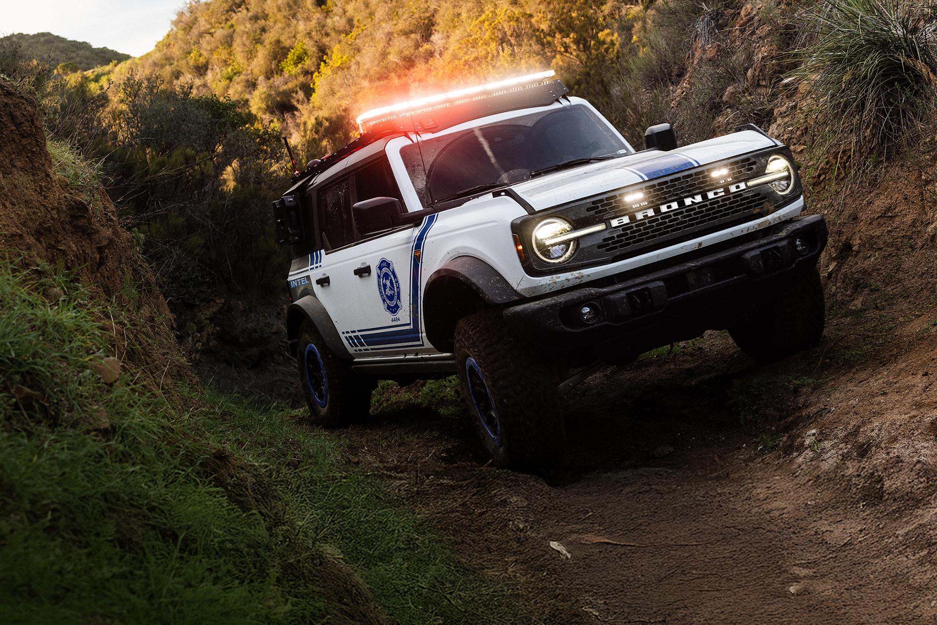A Ford Bronco Badlands equipped with search and rescue gear driving on an incline