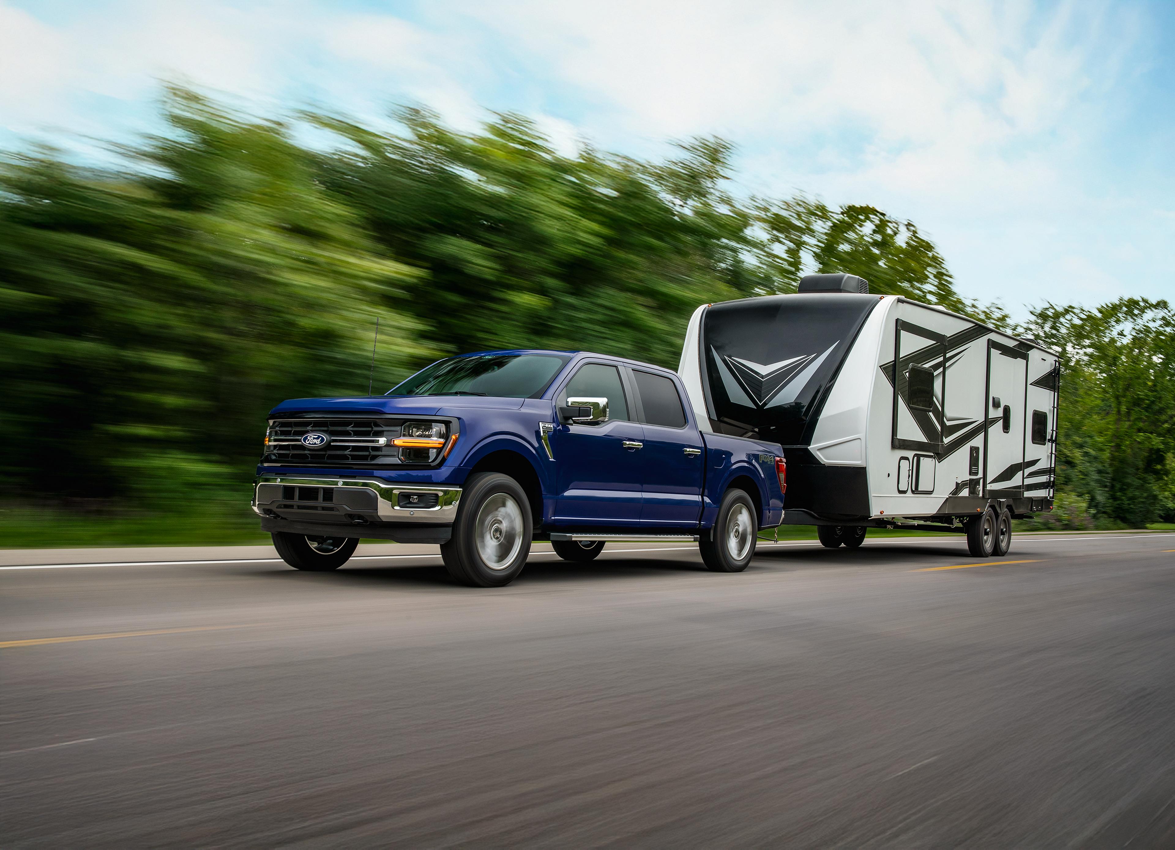 2026 Ford F-150® XL pickup in Atlas Blue Metallic pulling a camper
