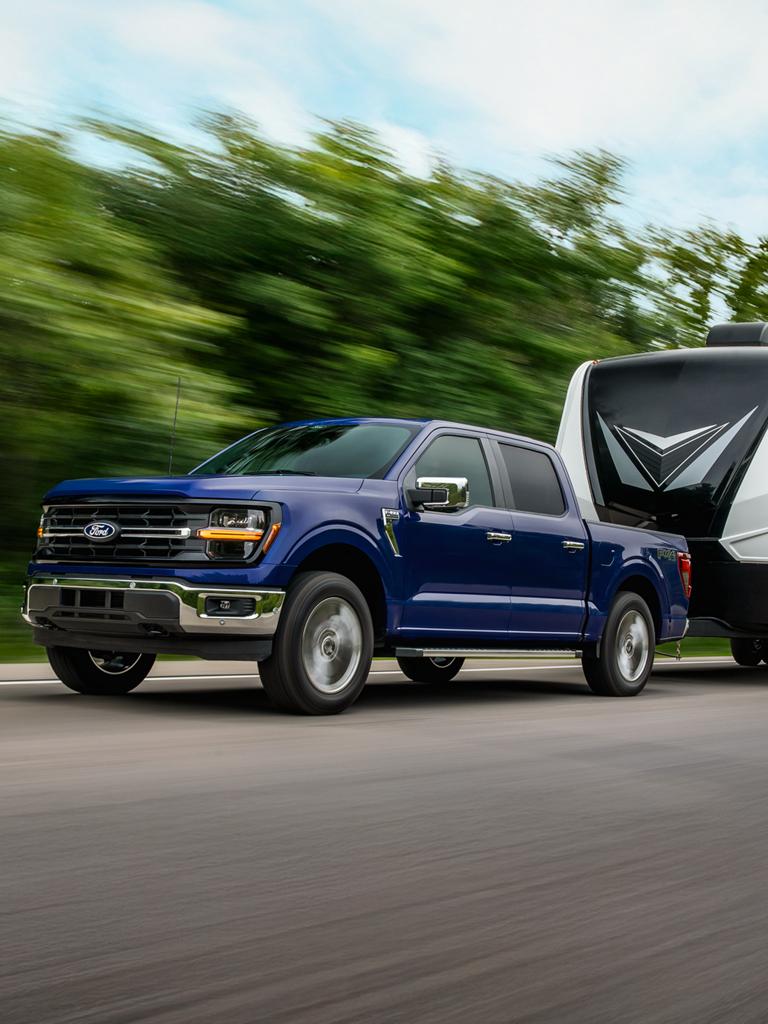 2026 Ford F-150® XL model in Atlas Bue Metallic pulling a camper
