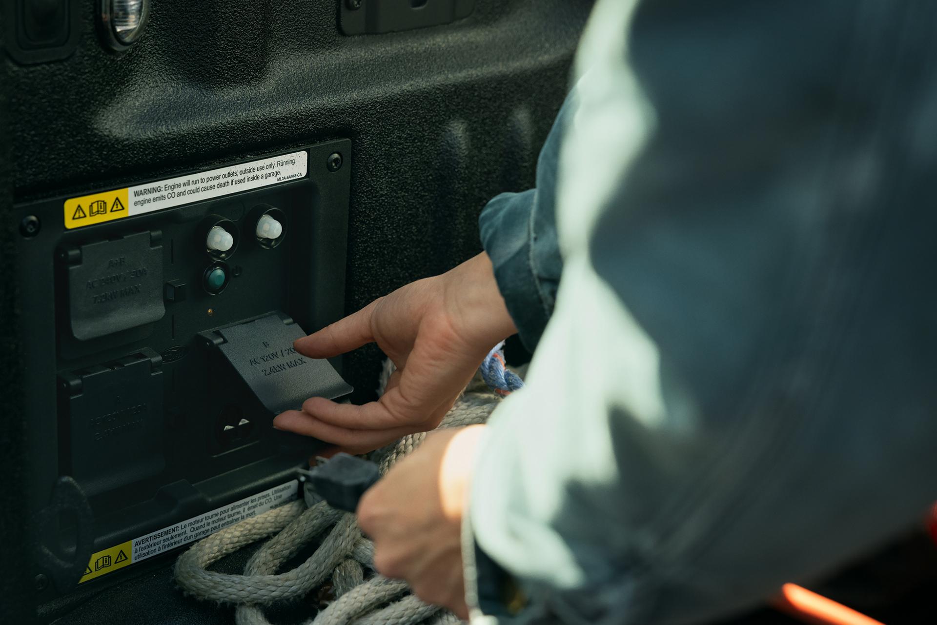 A worker plugging into Pro Power Onboard™ in the bed of a truck