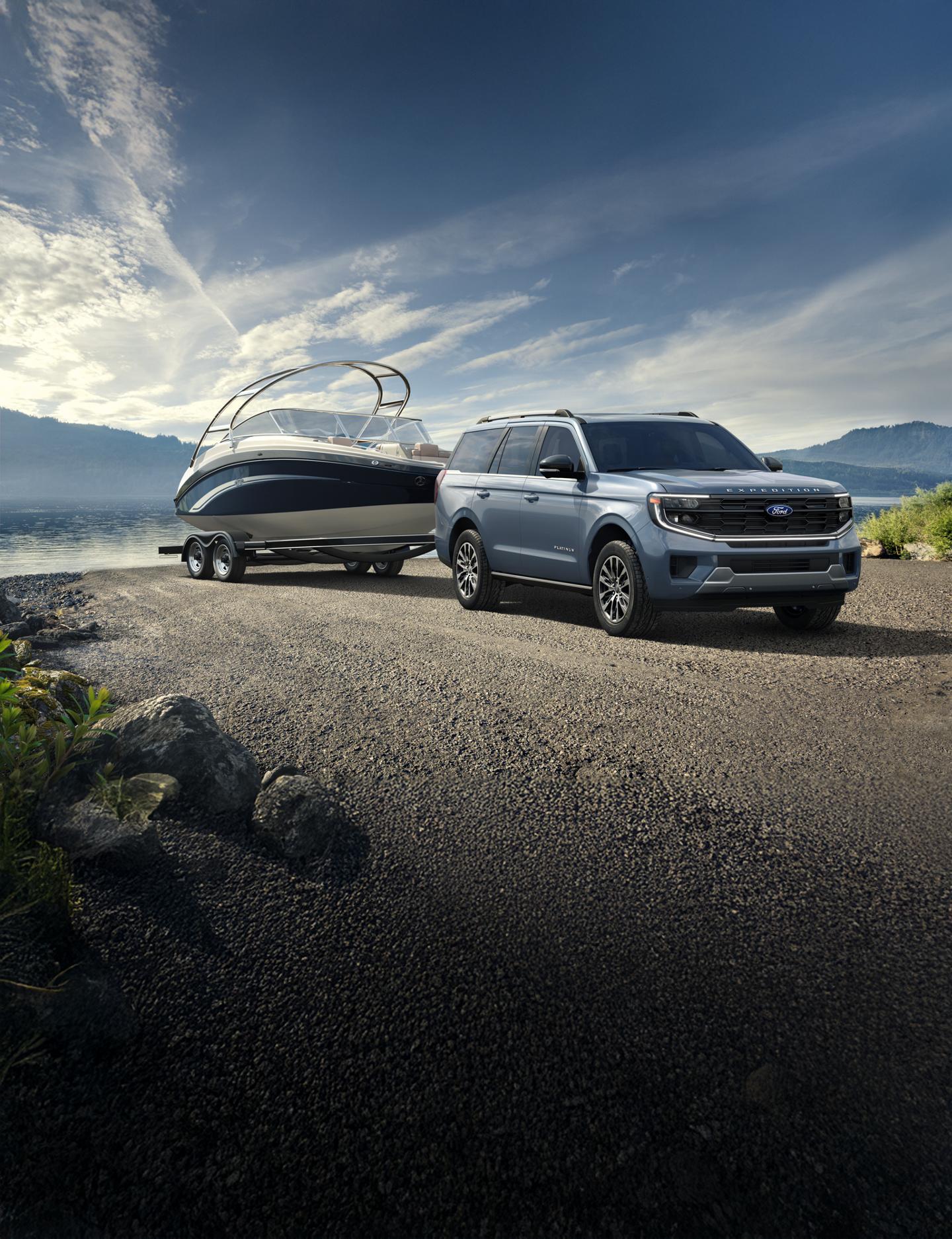 A blue 2025 Ford Expedition parked on gravel by a lake with a boat in tow