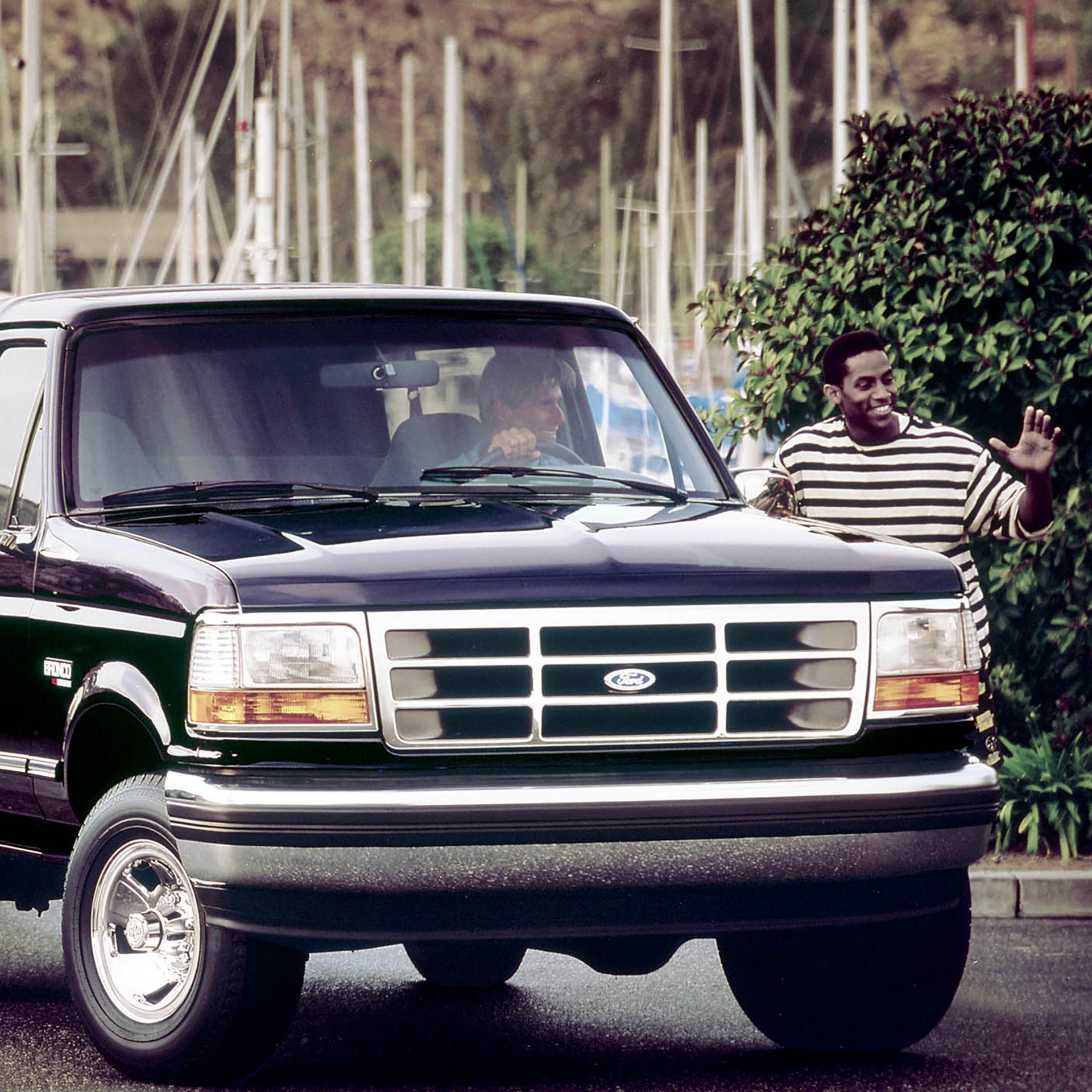 A vintage black 1994 Ford Bronco® model parked while set to tow a boat