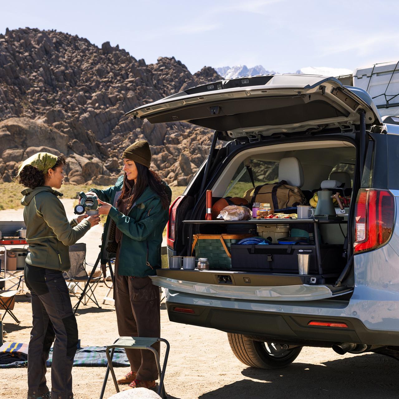 Two people near a parked 2027 Ford Expedition® Platinum® model with optional equipment and available Ford accessories shown