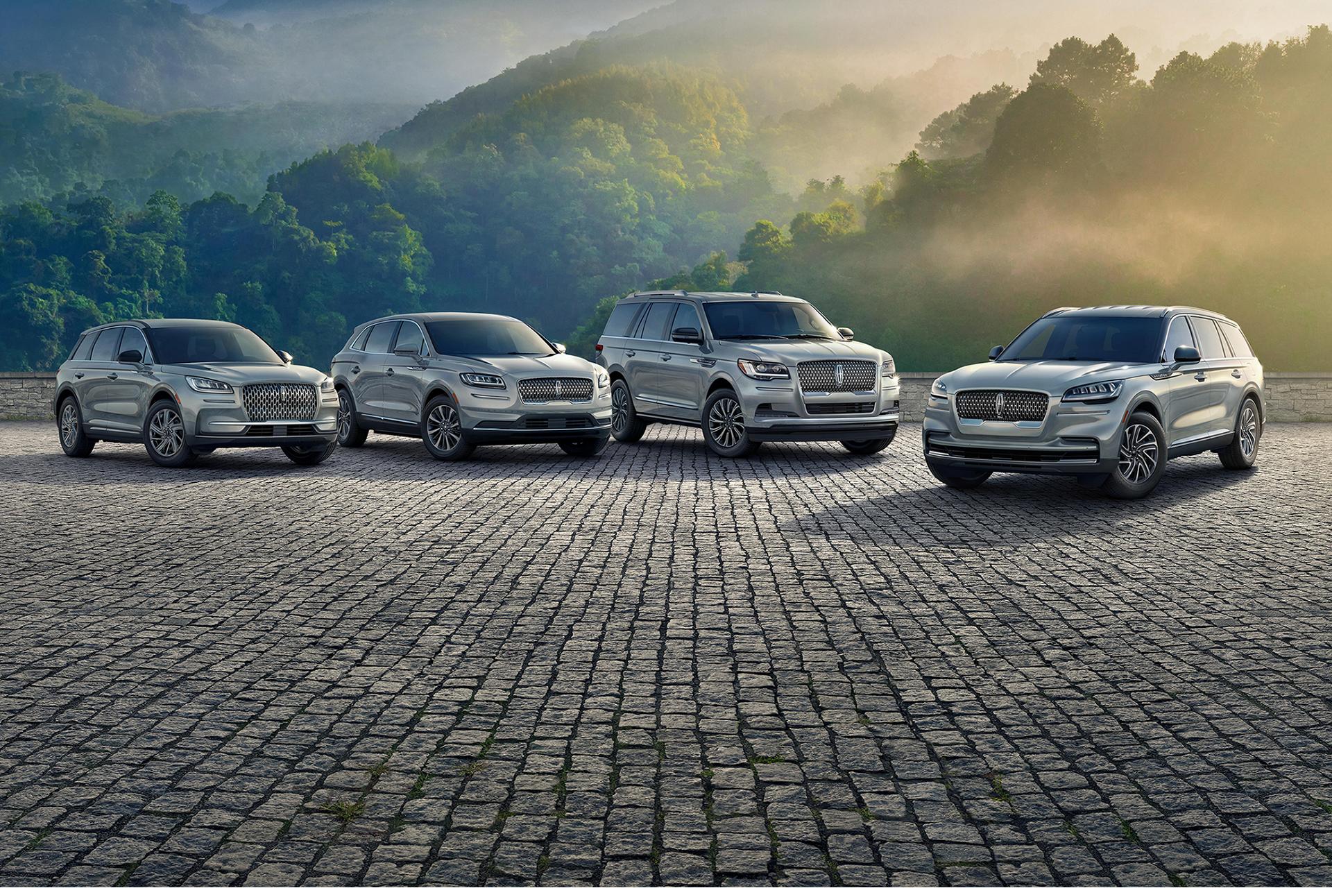 The Lincoln lineup of vehicles is parked before foothills at dawn