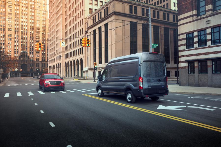 A 2025 Ford Transit® van stopped on the left-hand turn lane of an intersection