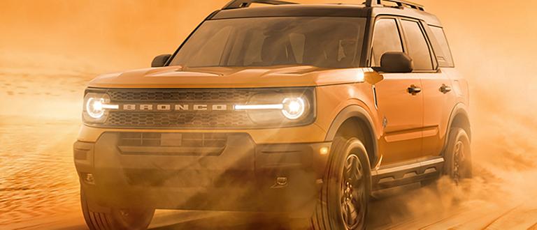 Two views of the 2026 Ford Bronco Sport® driving through the sand and snow