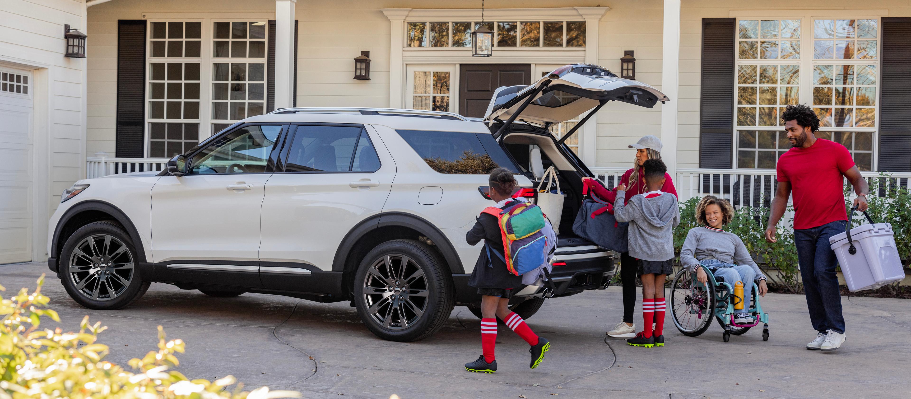 A family packing luggage into the rear of a 2026 Ford Explorer® SUV