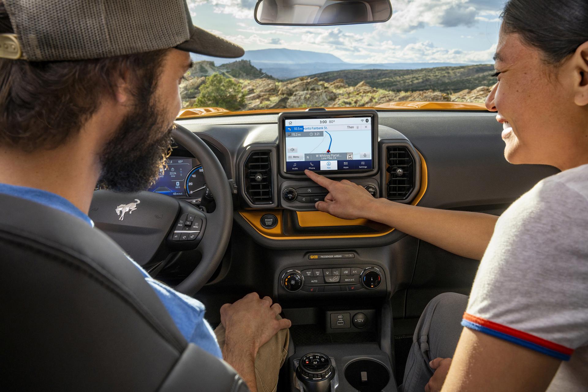 Passengers using the Ford touchscreen for connected navigation