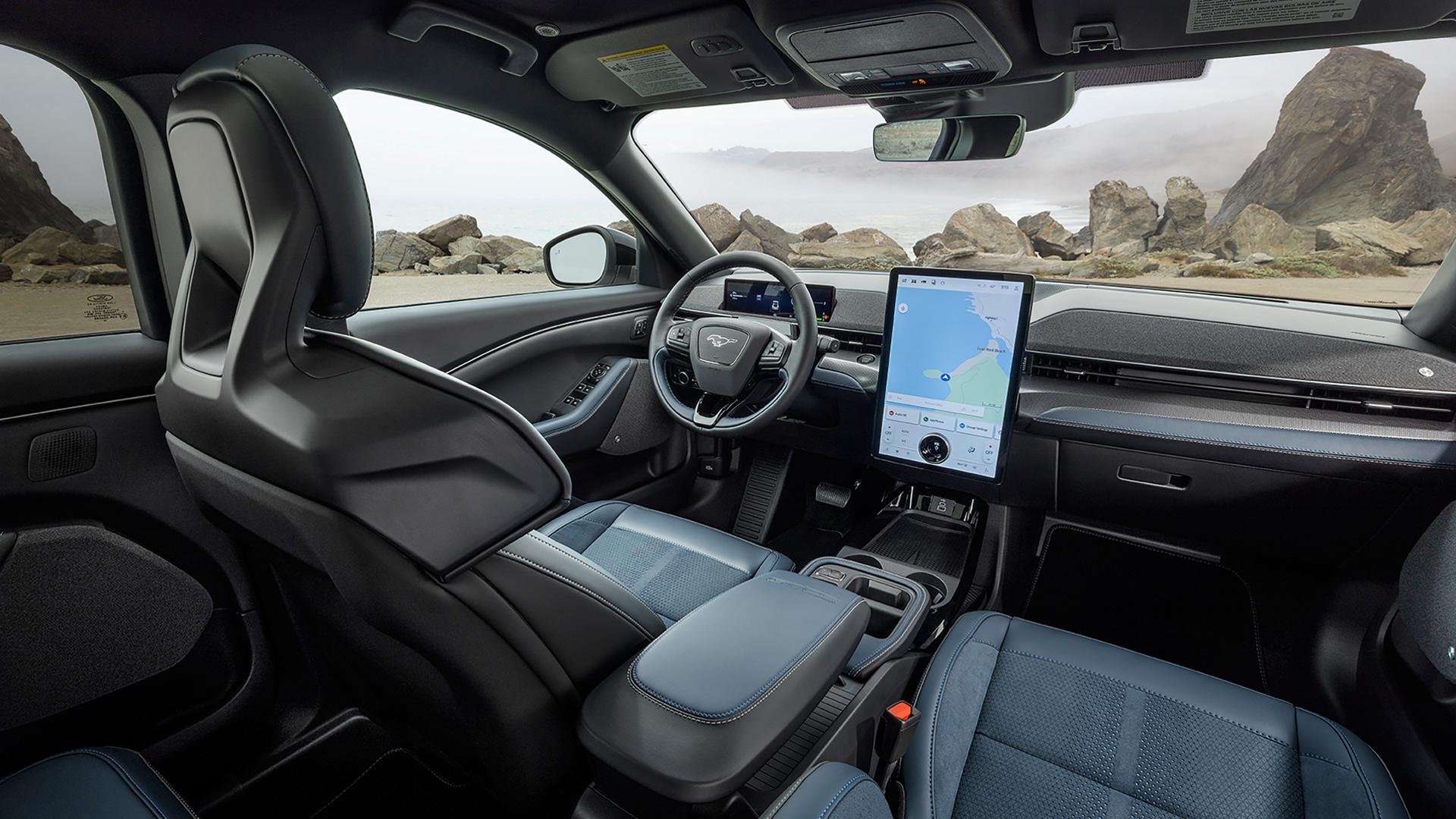 Interior of a 2026 Ford Mustang Mach-E® SUV with a view of the driver's seat, dashboard, and scenic rocky landscape