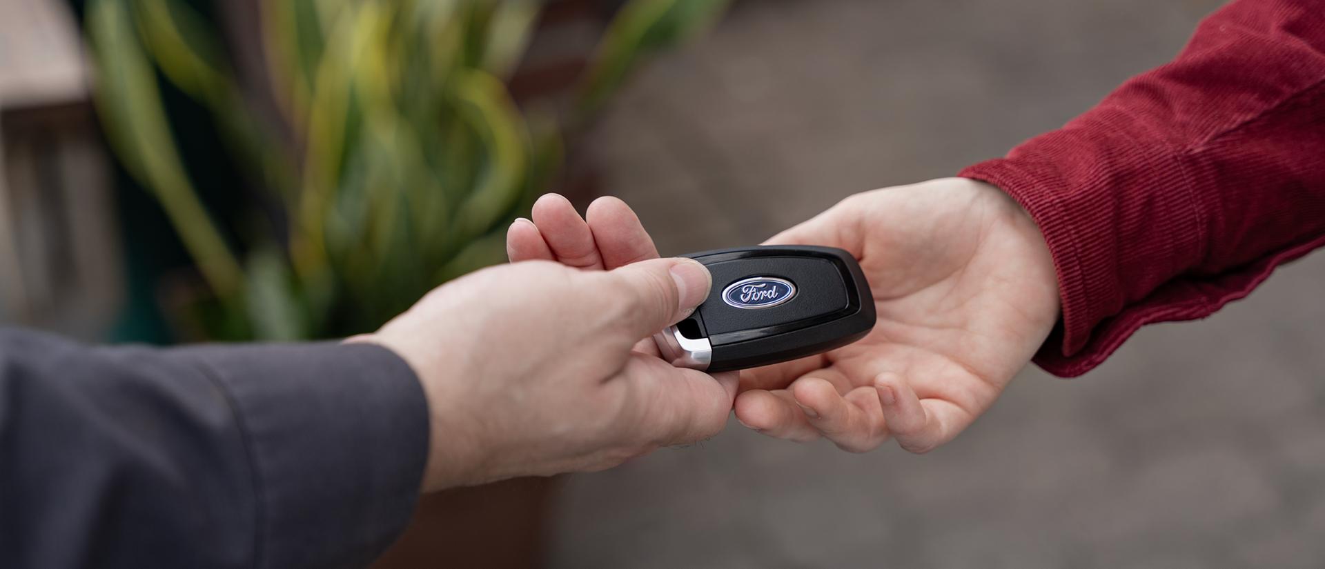 A Ford Mobile Service technician hands keys to a Ford owner