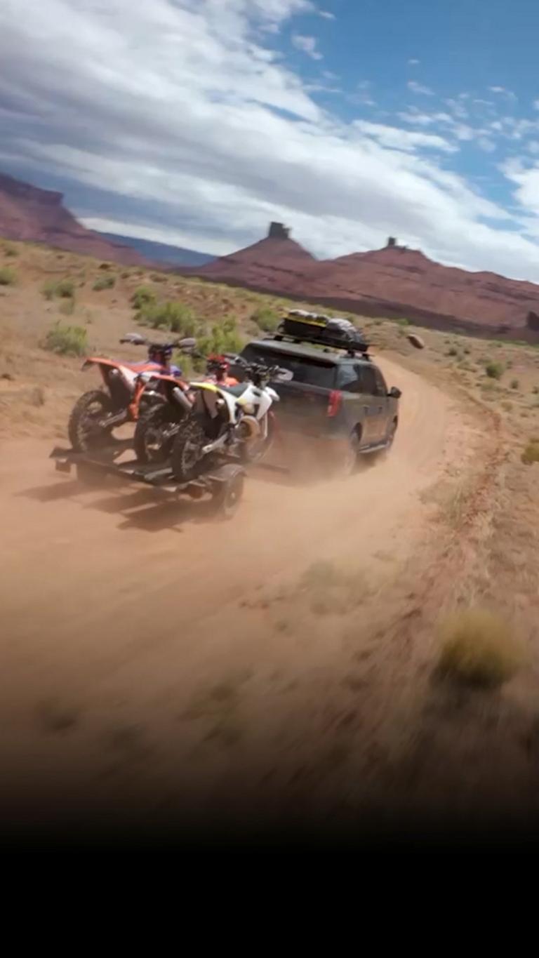 2026 Ford Expedition® Tremor® SUV hauling a trailer of dirt bikes in the desert
