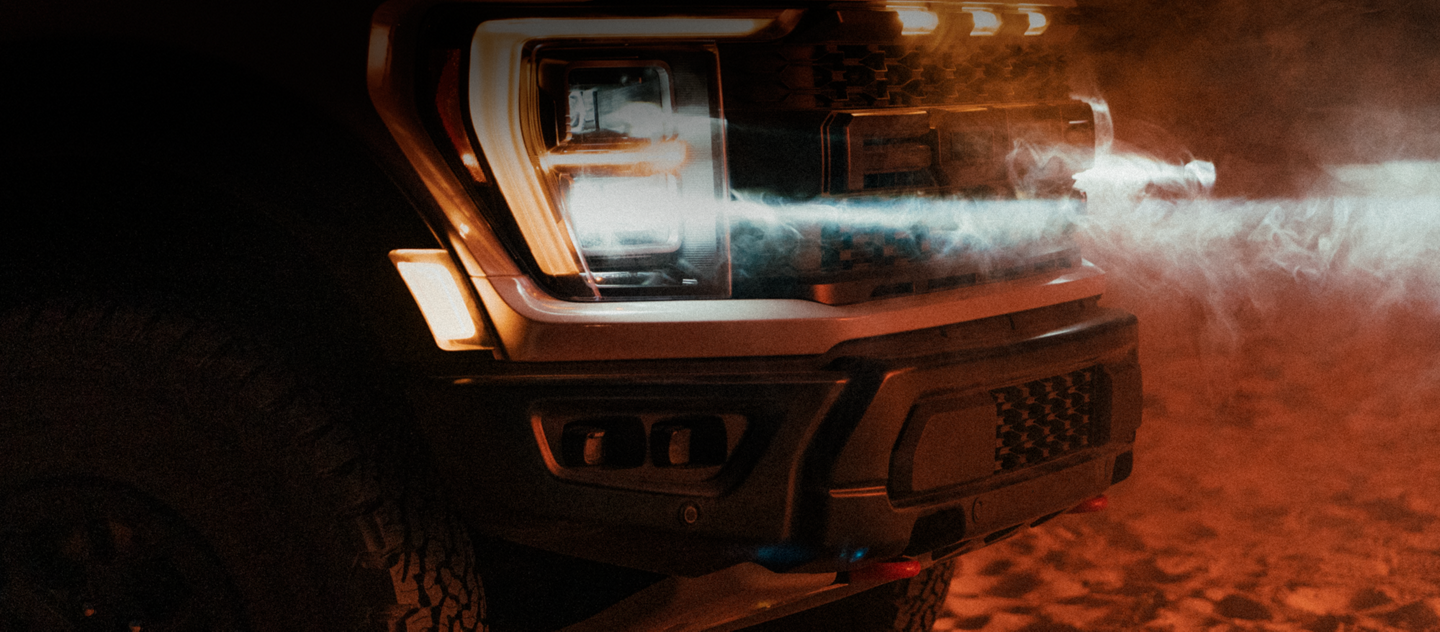 Close-up on the headlamps of the 2023 Ford F-150® Raptor® R with dust blowing