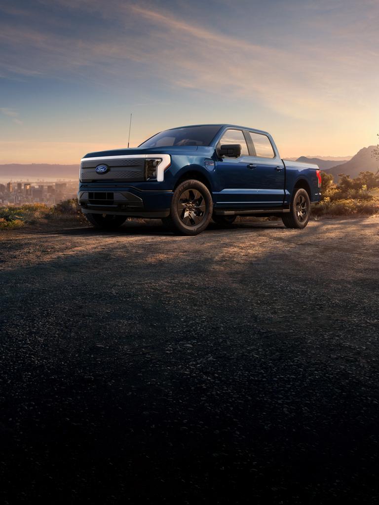 Ford F-150® Lightning® parked next to a field at dusk