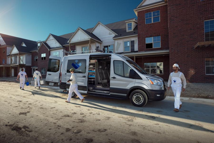 A 2025 Ford Transit® van at a job site with sliding and rear doors open