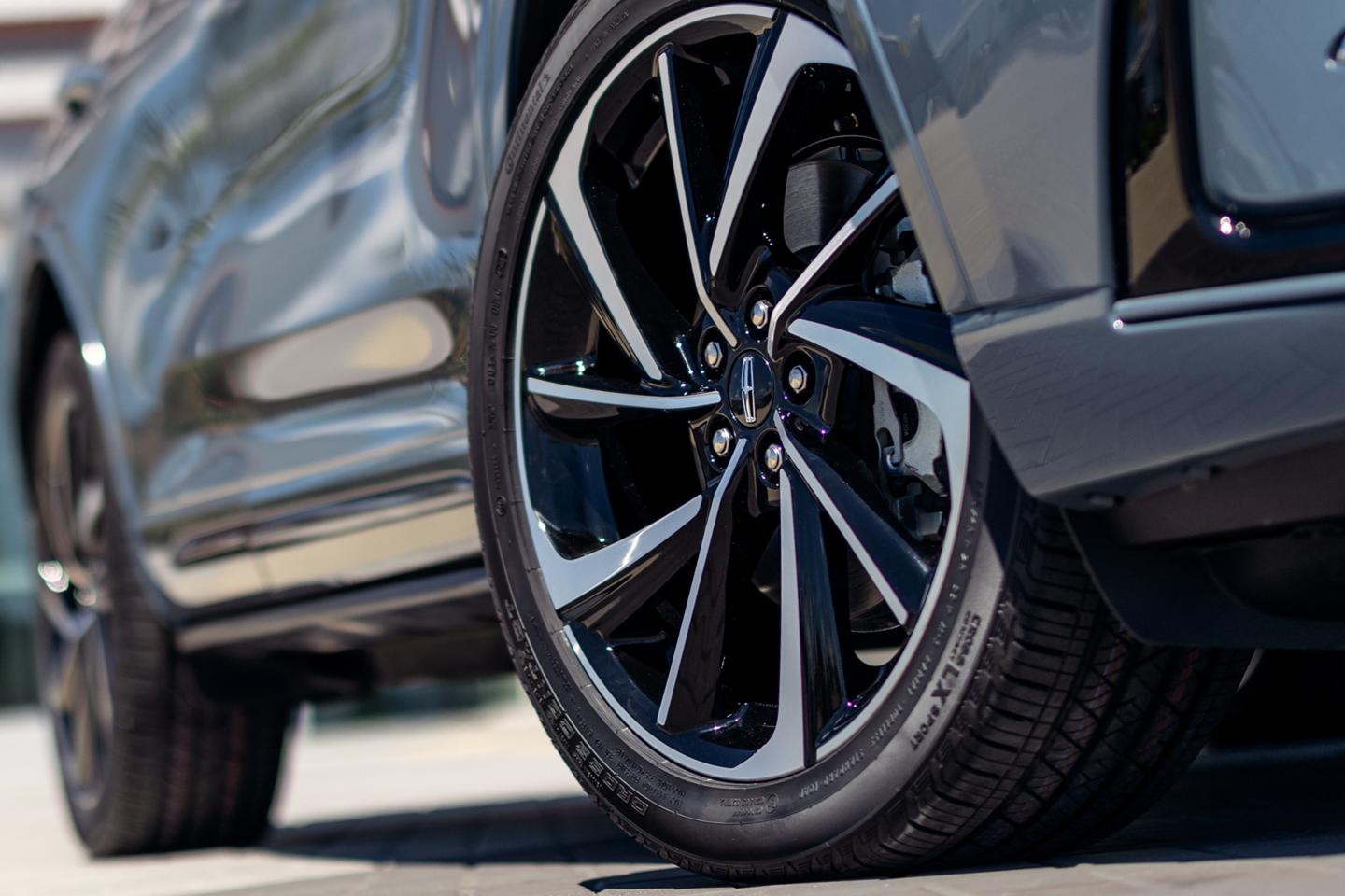 The available 20-inch aluminum wheels with black premium paint are shown on the Grand Touring model