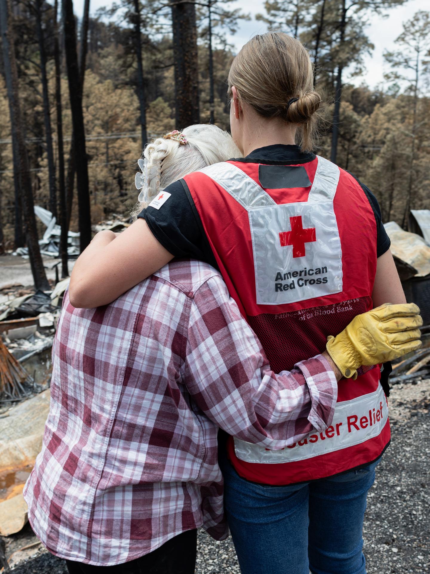 A Red Cross volunteer hugging someone that lost her home