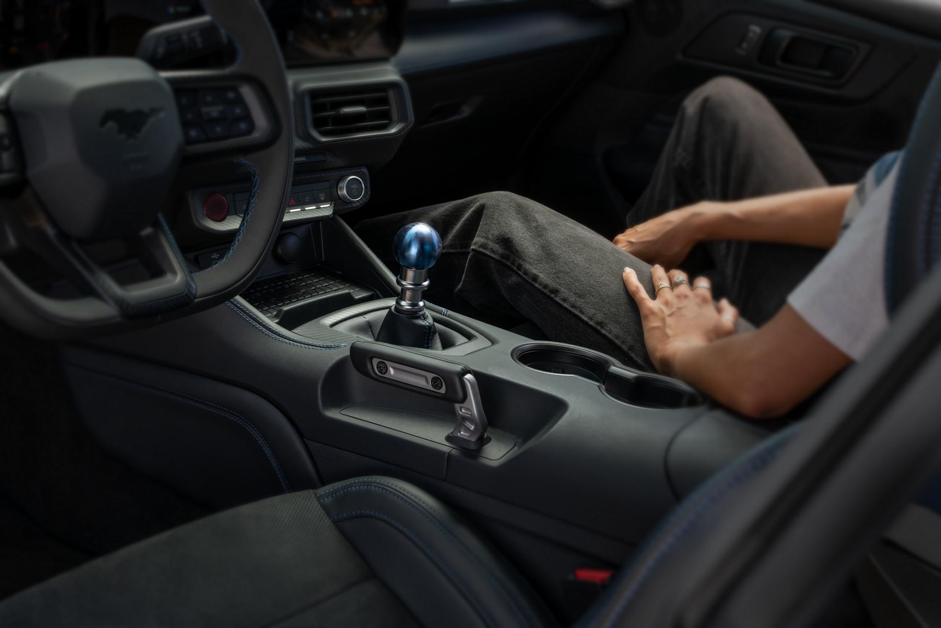 Person sitting in a 2026 Ford Mustang Dark Horse® Fastback with unique titanium Anodized Blue shift knob