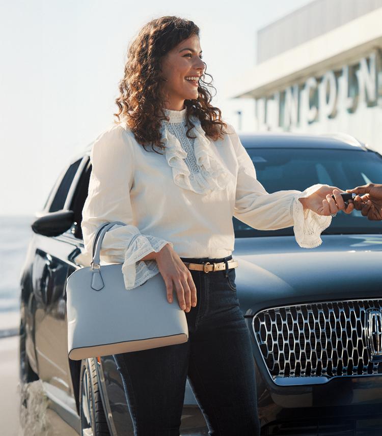 A woman picking up her Lincoln vehicle.