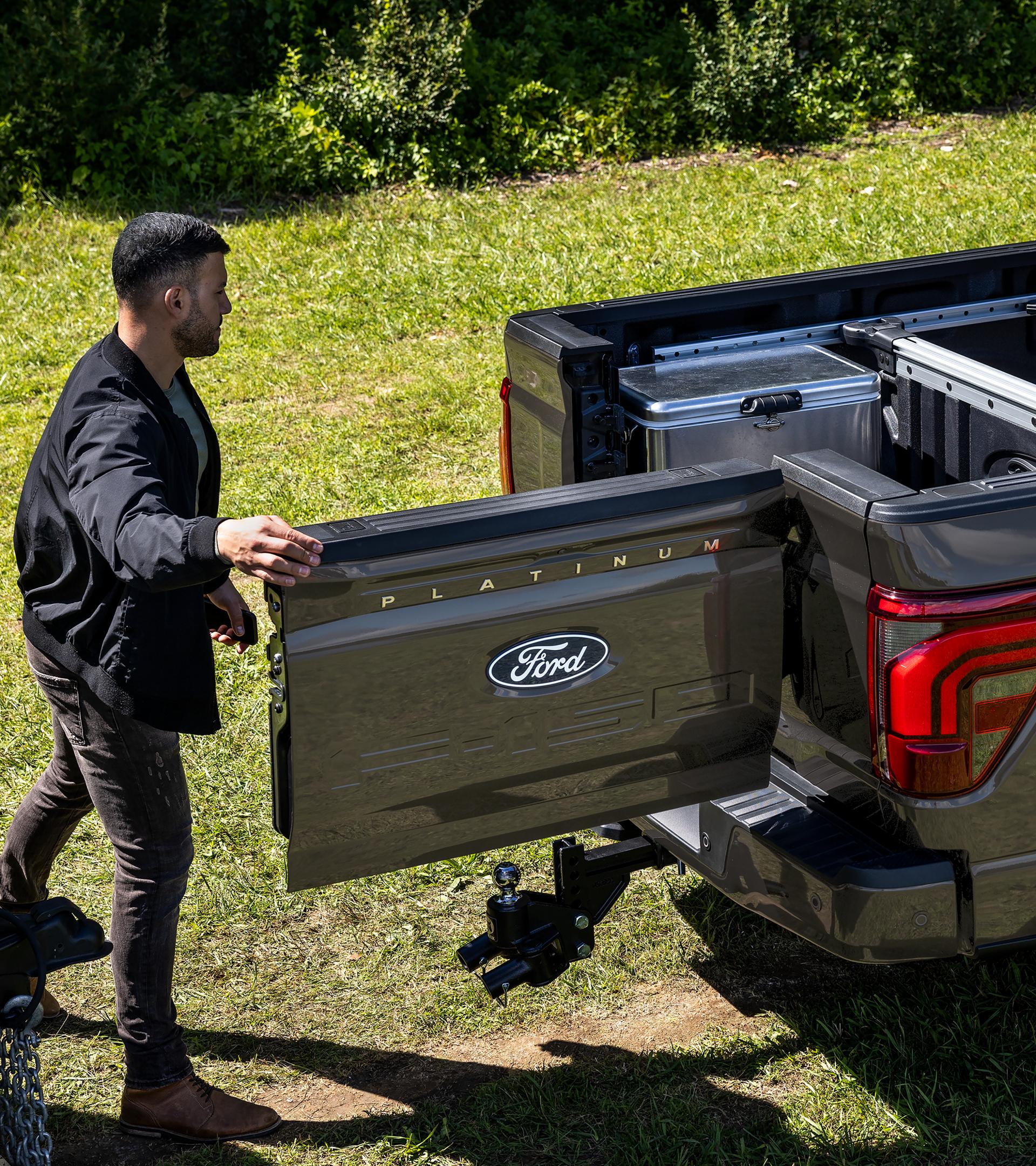 A man accesses the integrated swing gate of a 2025 Ford F-150® pickup with the Pro-Access Tailgate