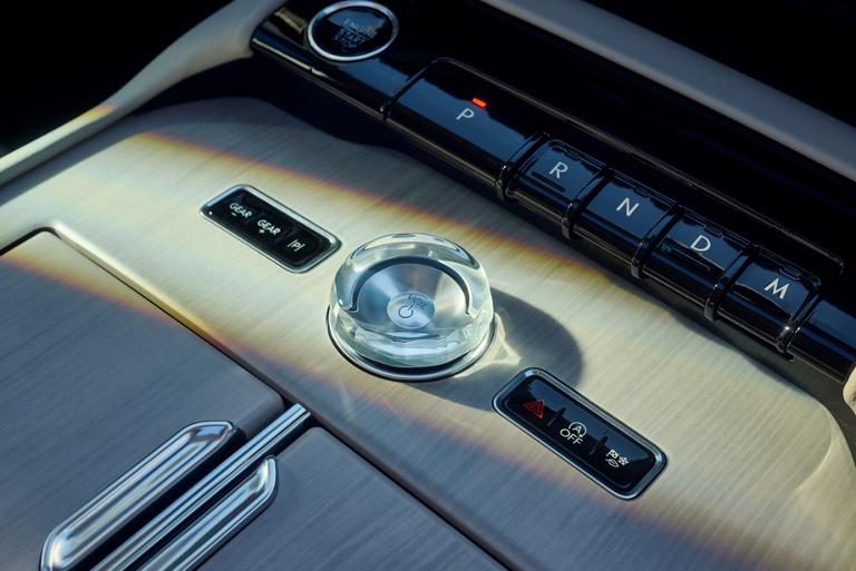 Primer plano de la perilla de cristal y la palanca de cambios tipo teclas de piano en la consola central de una Lincoln Navigator® 2026