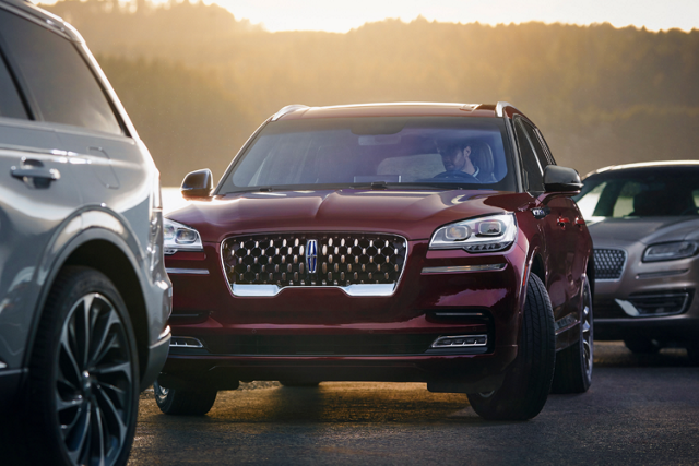 a Lincoln vehicle between two vehicles in traffic is shown here