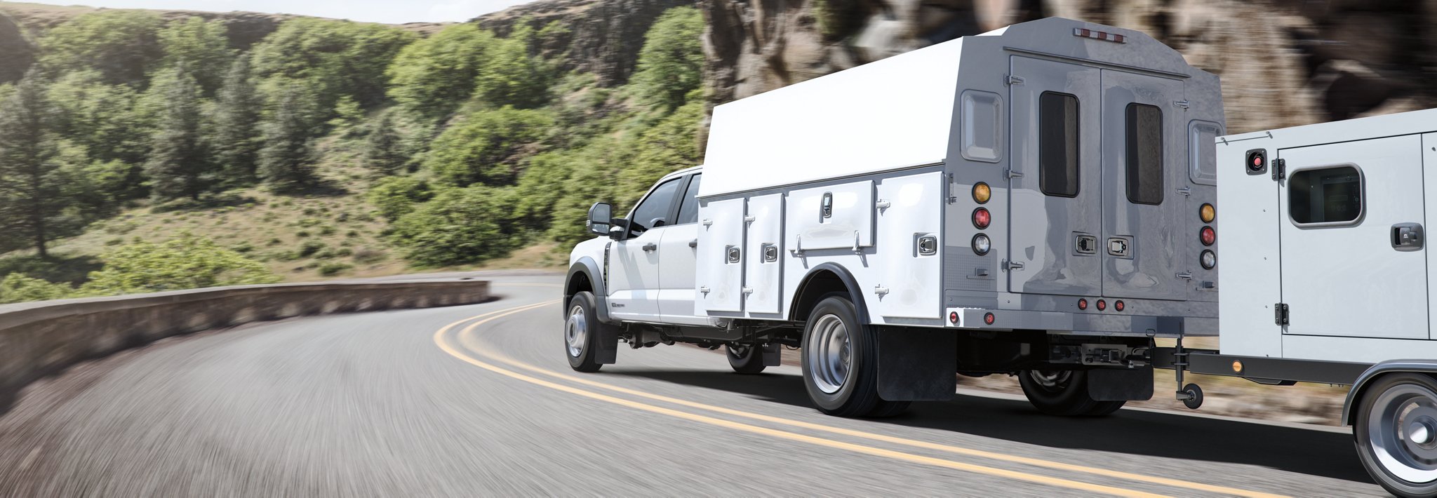 2025 Ford Super Duty® with a utility box being driven up a road alongside a mountain