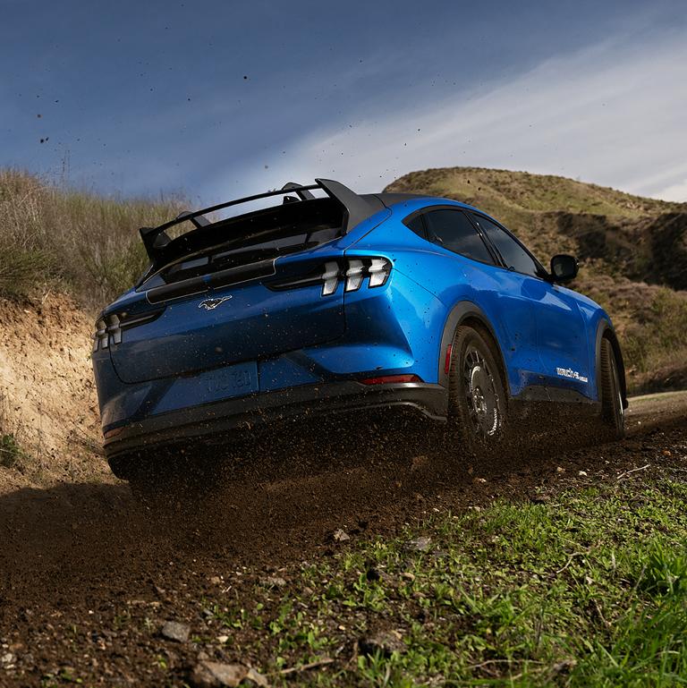 Rear end of a 2026 Ford Mustang Mach-E® Rally model on a dirt road