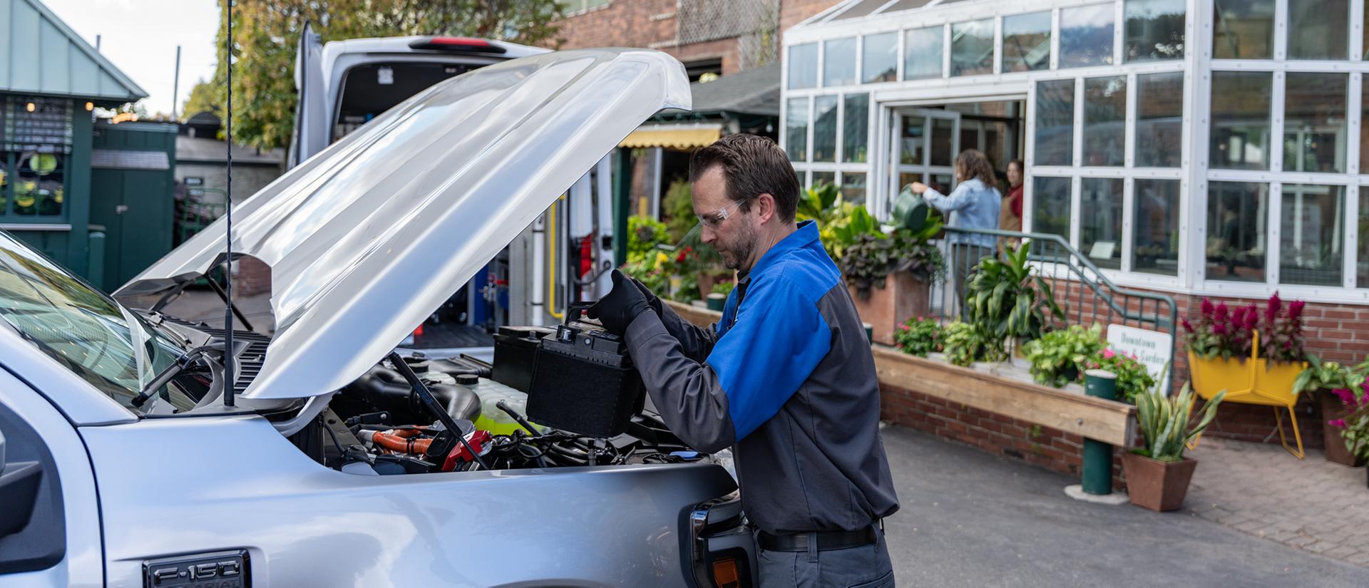 A Ford Mobile Service technician replaces a battery