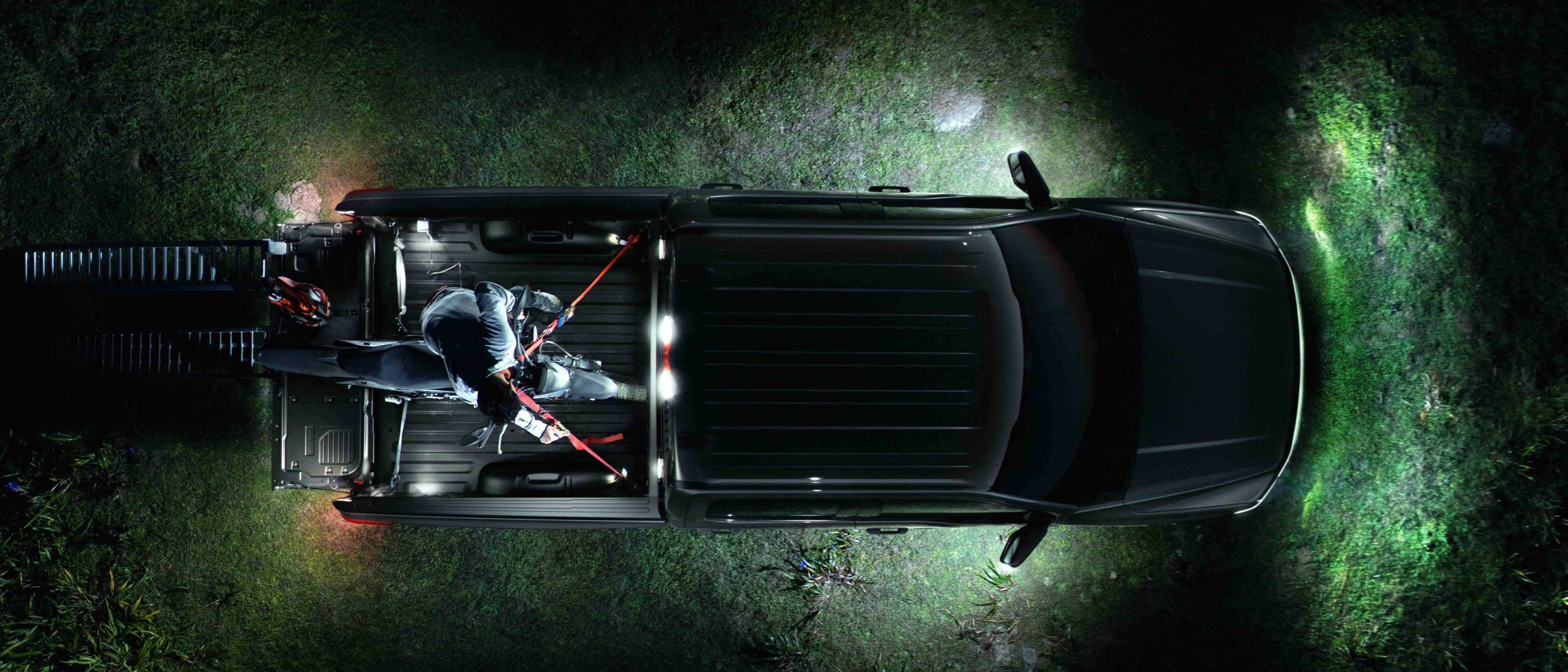An overhead view of a 2025 Ford F-150® Lightning® pickup, with the LED Zone Lighting illuminating the area around