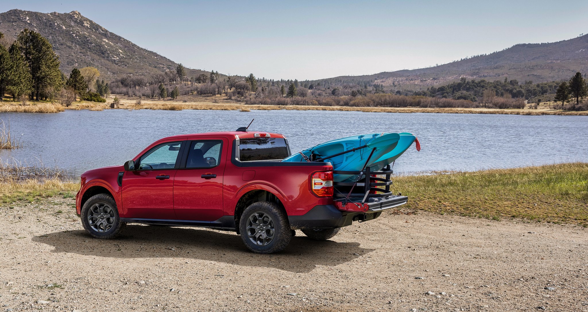 2026 Ford Maverick® Lariat® parked near a lake with two kayaks in the bed. Optional equipment shown.